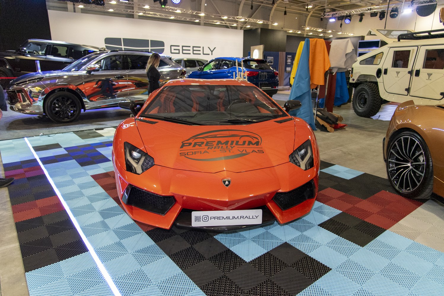 Front profile of an orange luxury sports car with distinctive angular headlights.