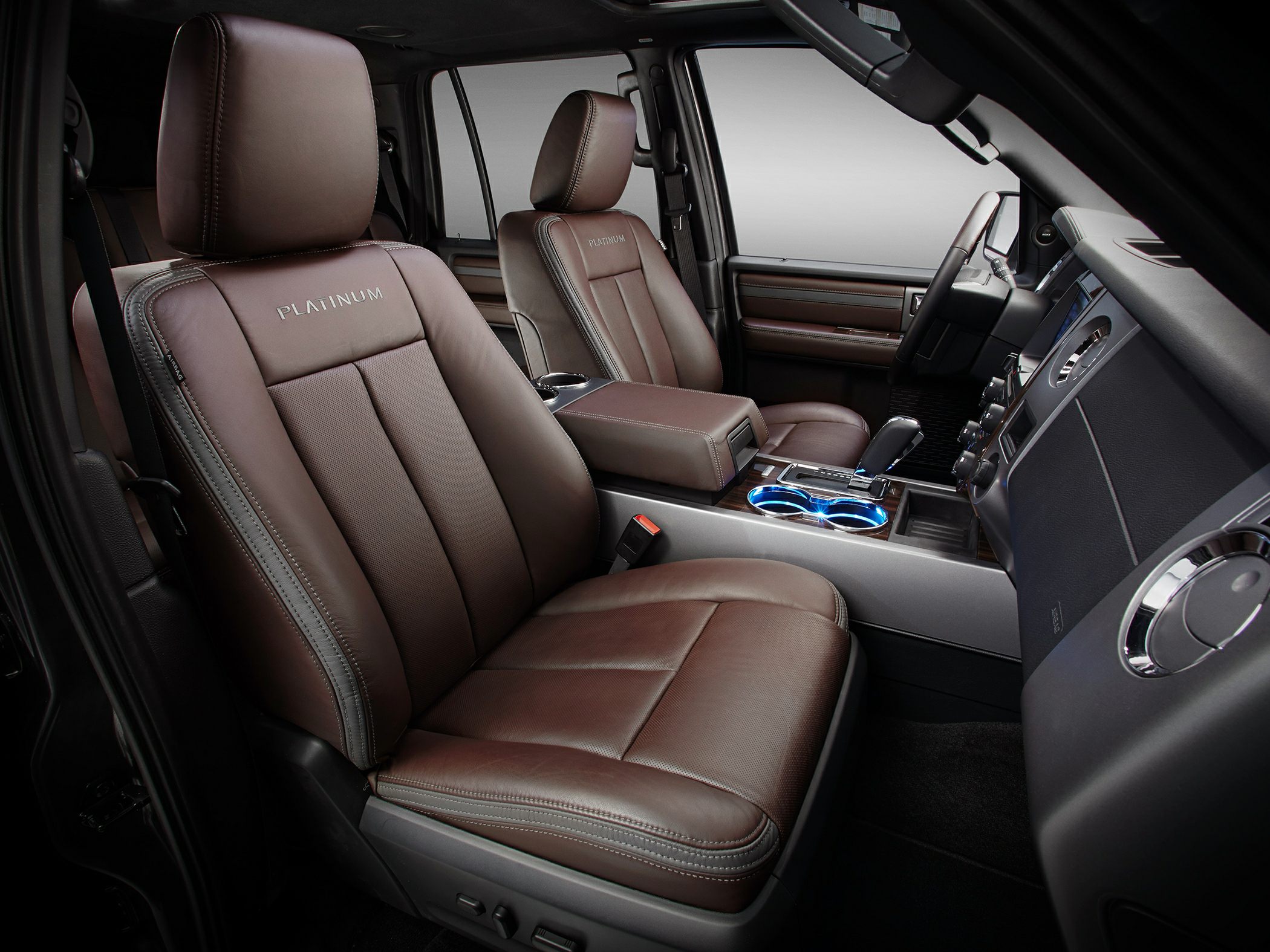 Brown leather platinum seats and illuminated cup holders in SUV interior