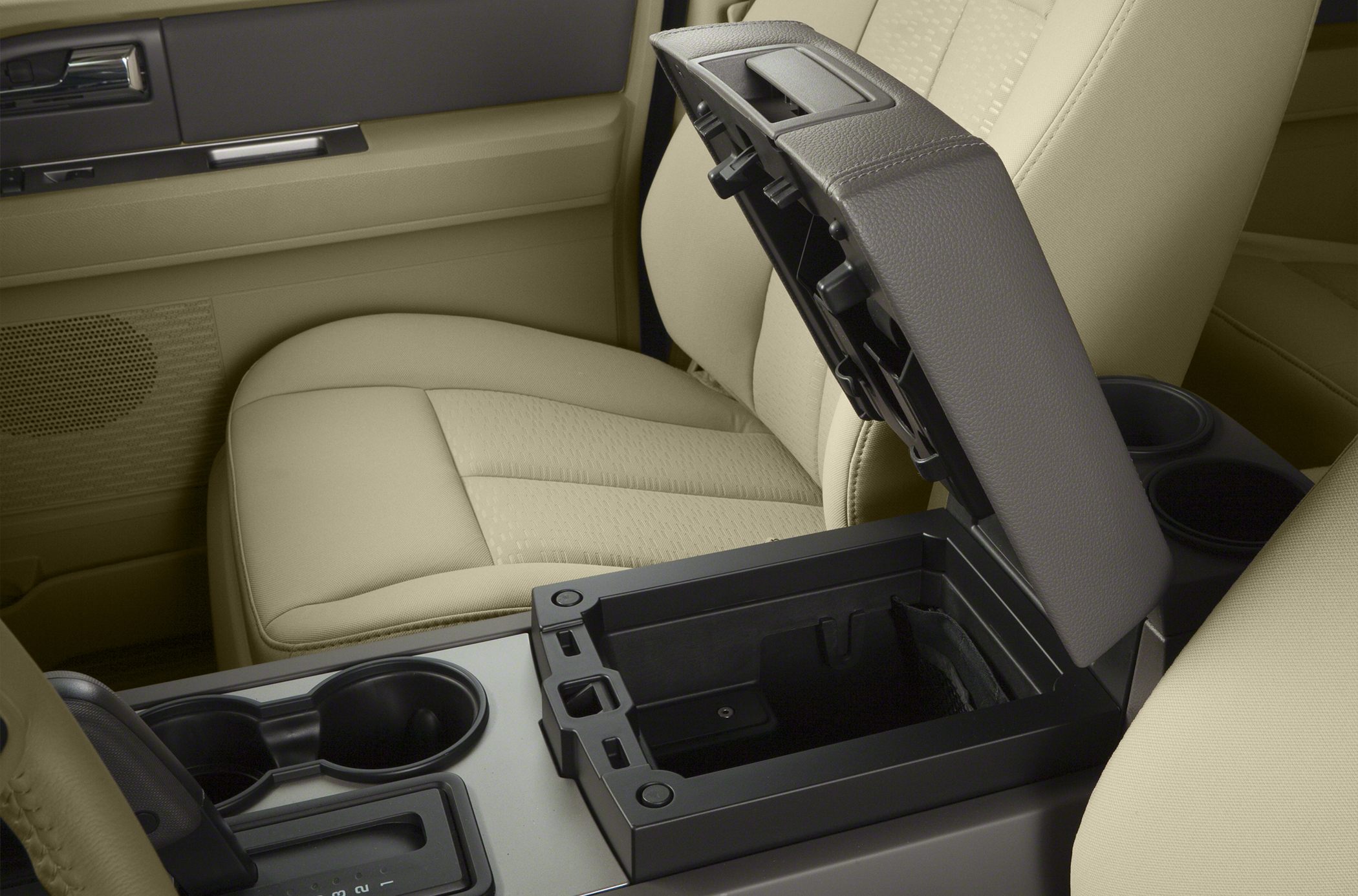 Open center console storage with dual cup holders and beige leather seats