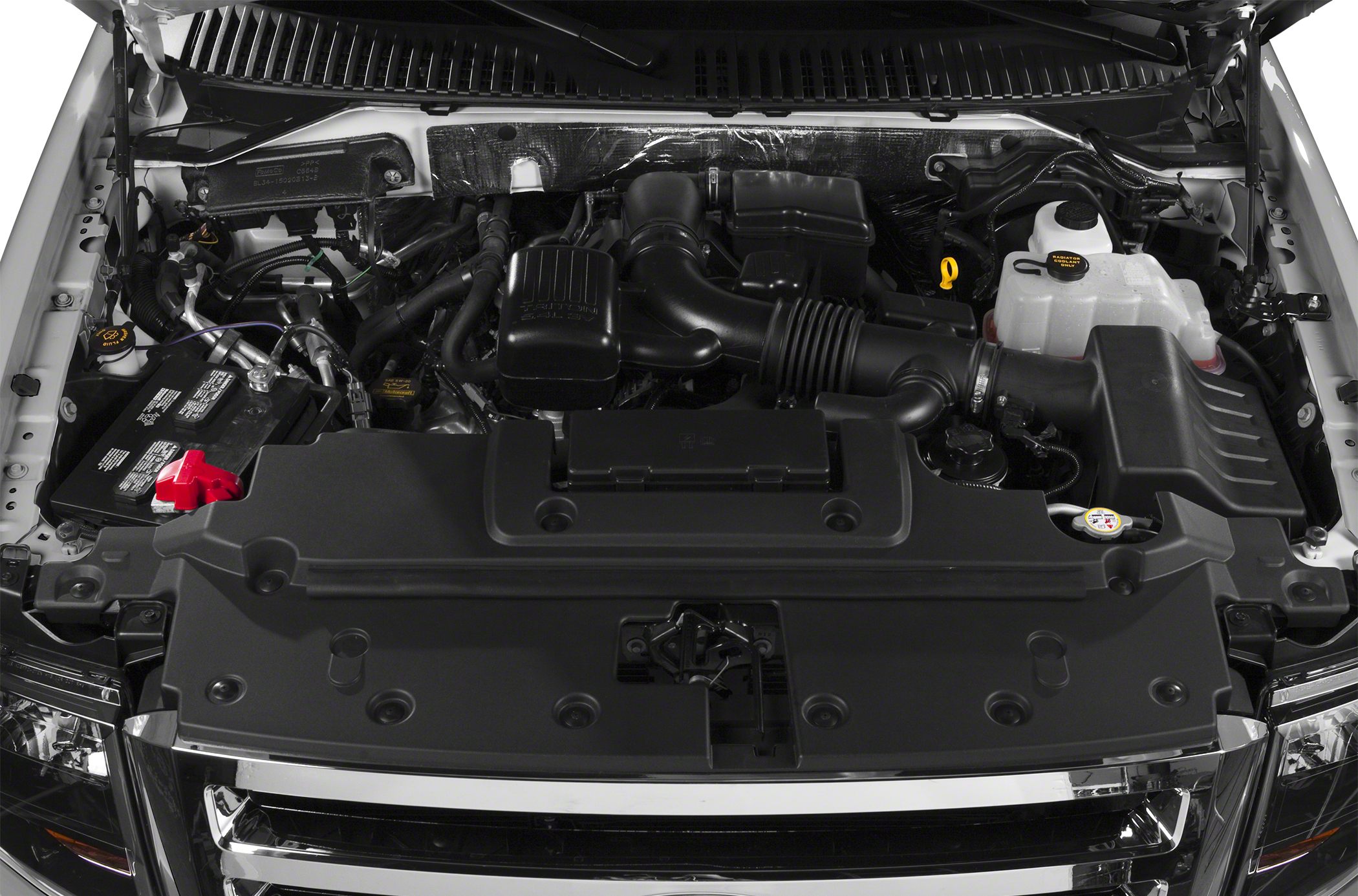 Engine bay view featuring air intake system, battery, and coolant reservoir