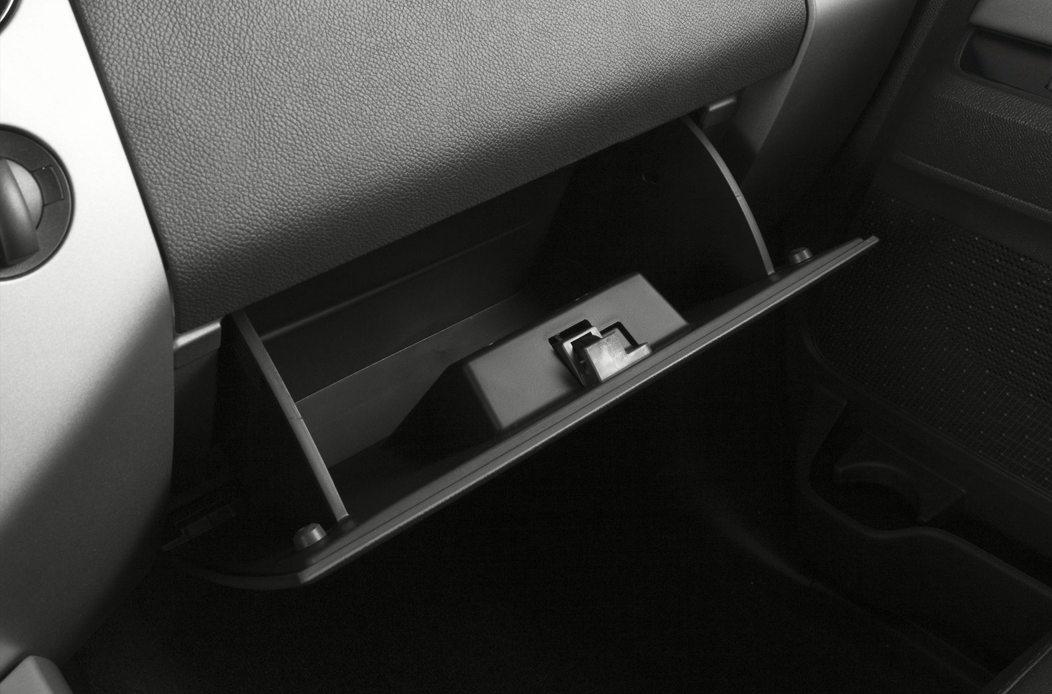 Open glove compartment with storage slot and latch mechanism inside vehicle dashboard
