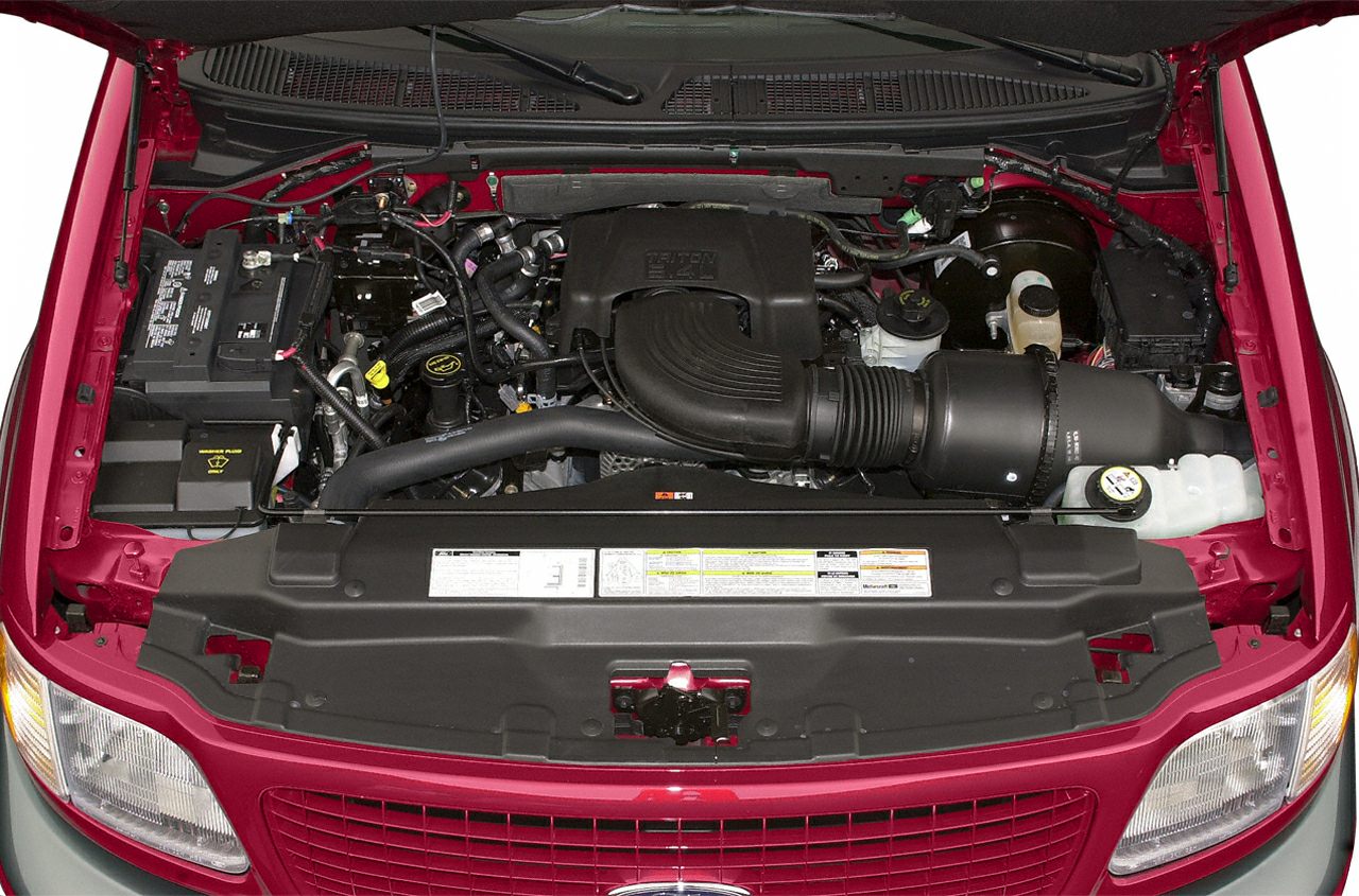 Engine bay showing air intake, battery, and engine components under the hood.