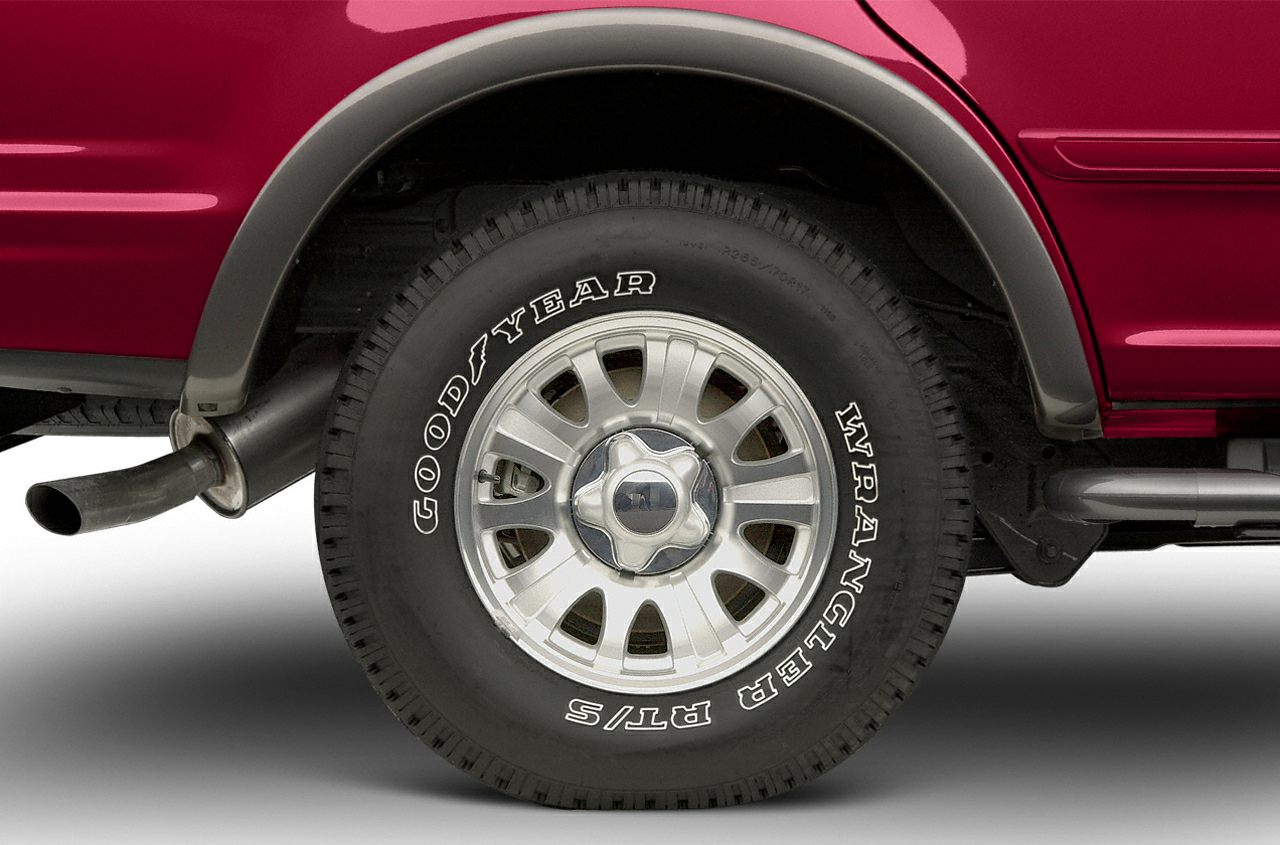Close-up of rear wheel with Goodyear Wrangler tire and exhaust pipe