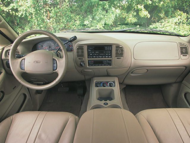 Dashboard and steering wheel of SUV interior with center console and seat upholstery