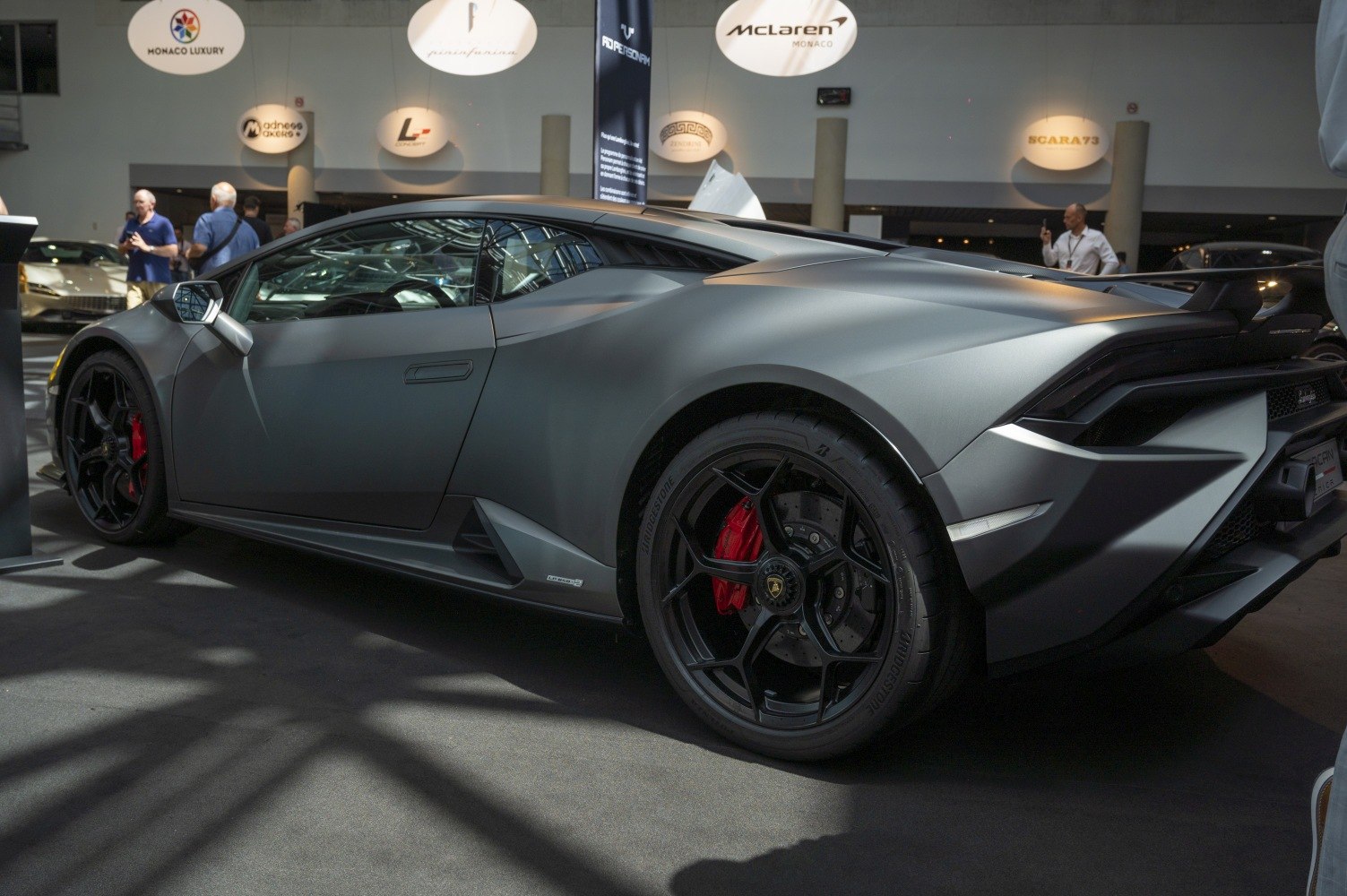 Side profile of a sports coupe with black wheels and red brake calipers.
