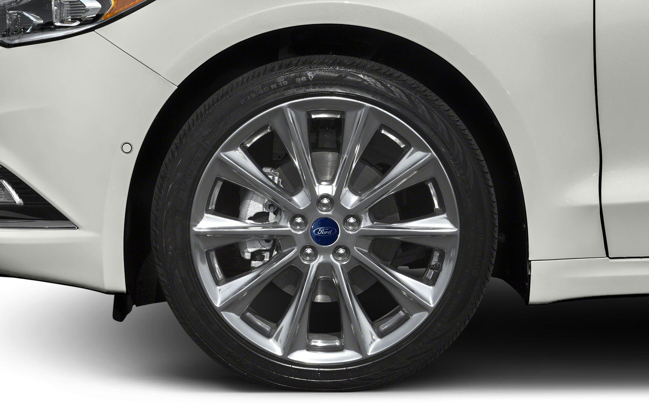 Close-up of multi-spoke alloy wheel and tire on a white car.