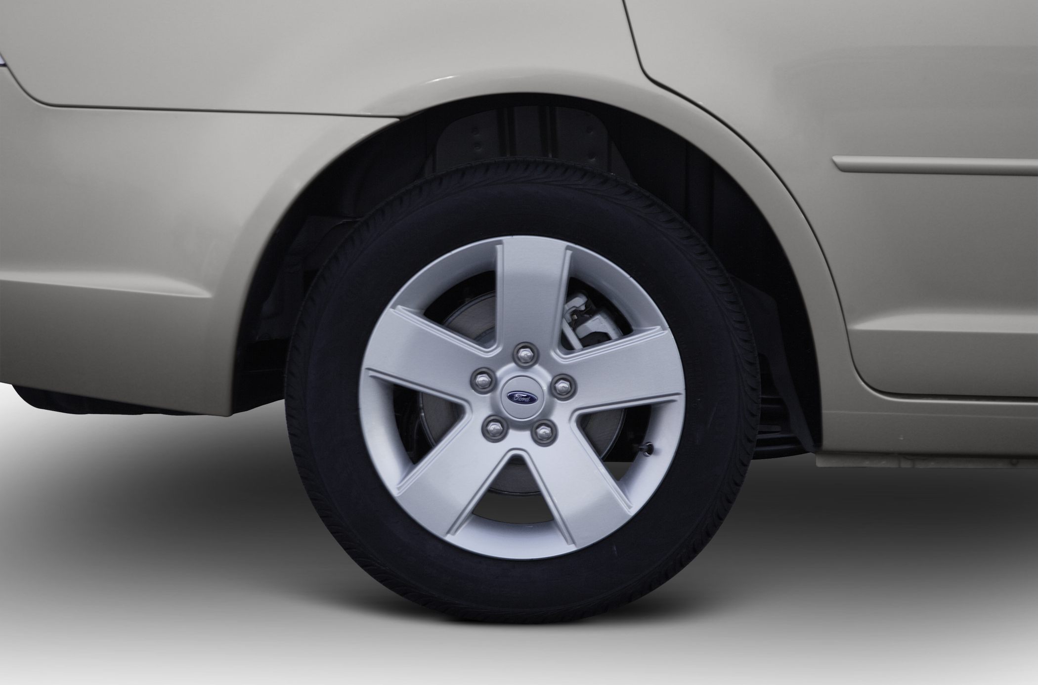 Close-up of rear alloy wheel and tire on sedan.