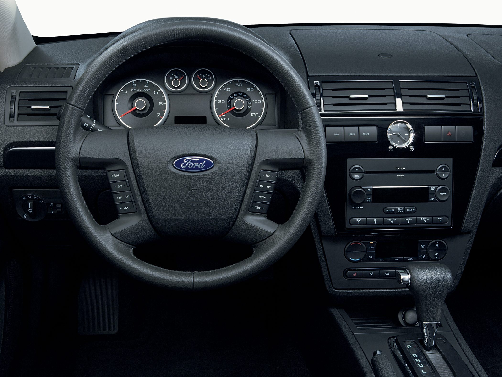 Steering wheel, dashboard with analog gauges, and center console.