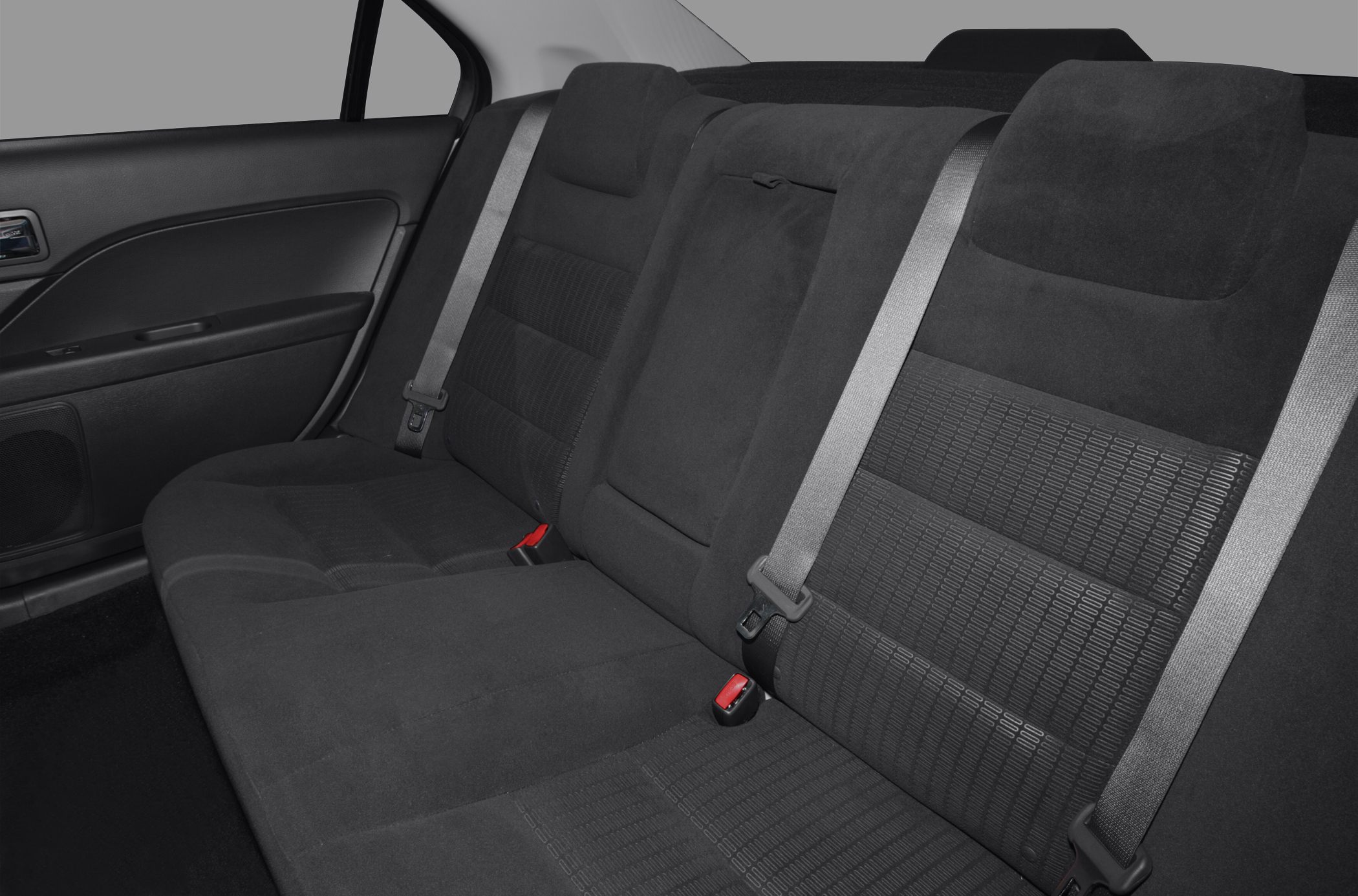 Rear seat interior with fabric upholstery, seat belts, and center armrest