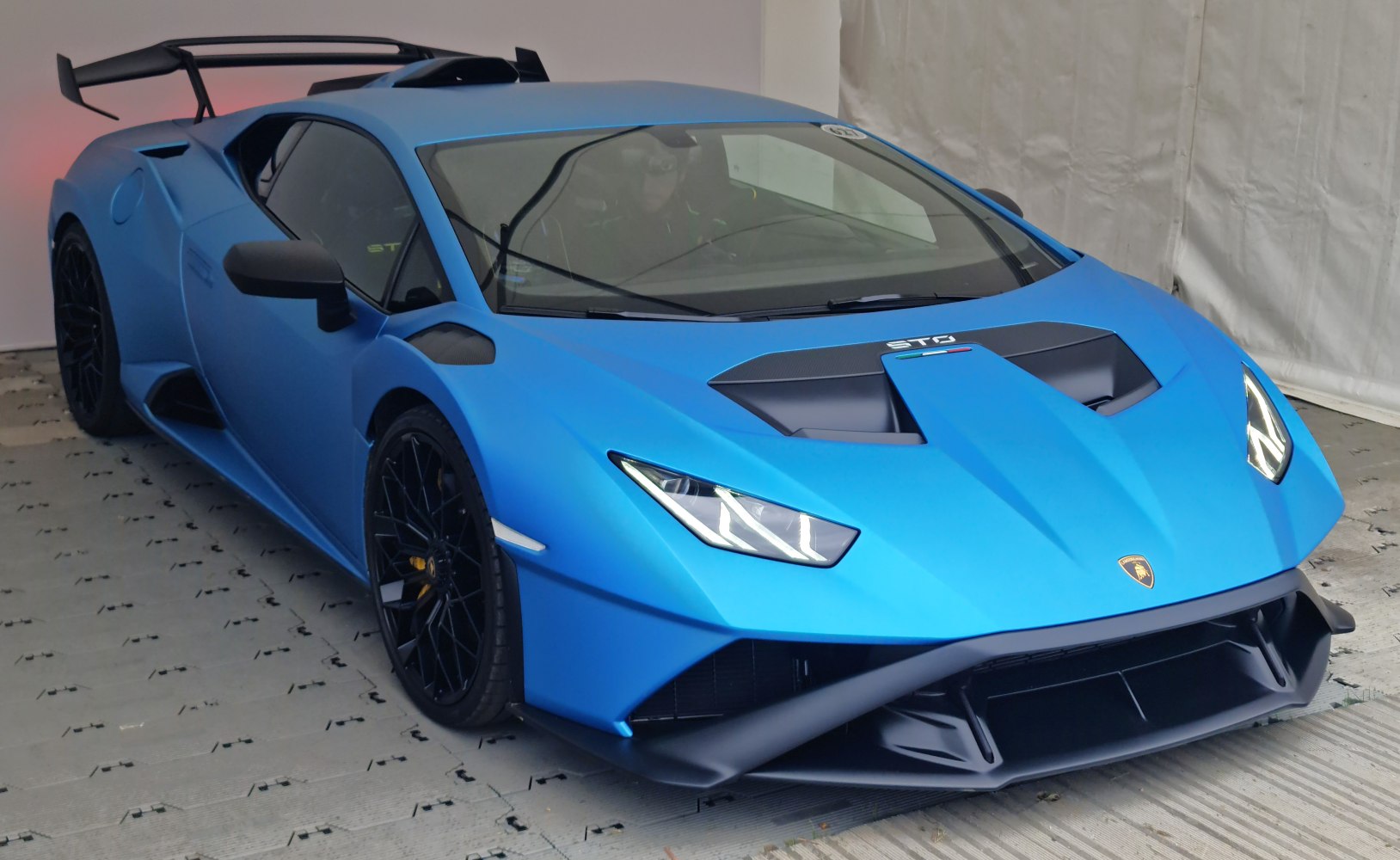 Blue sports car with aggressive aerodynamics and large rear wing