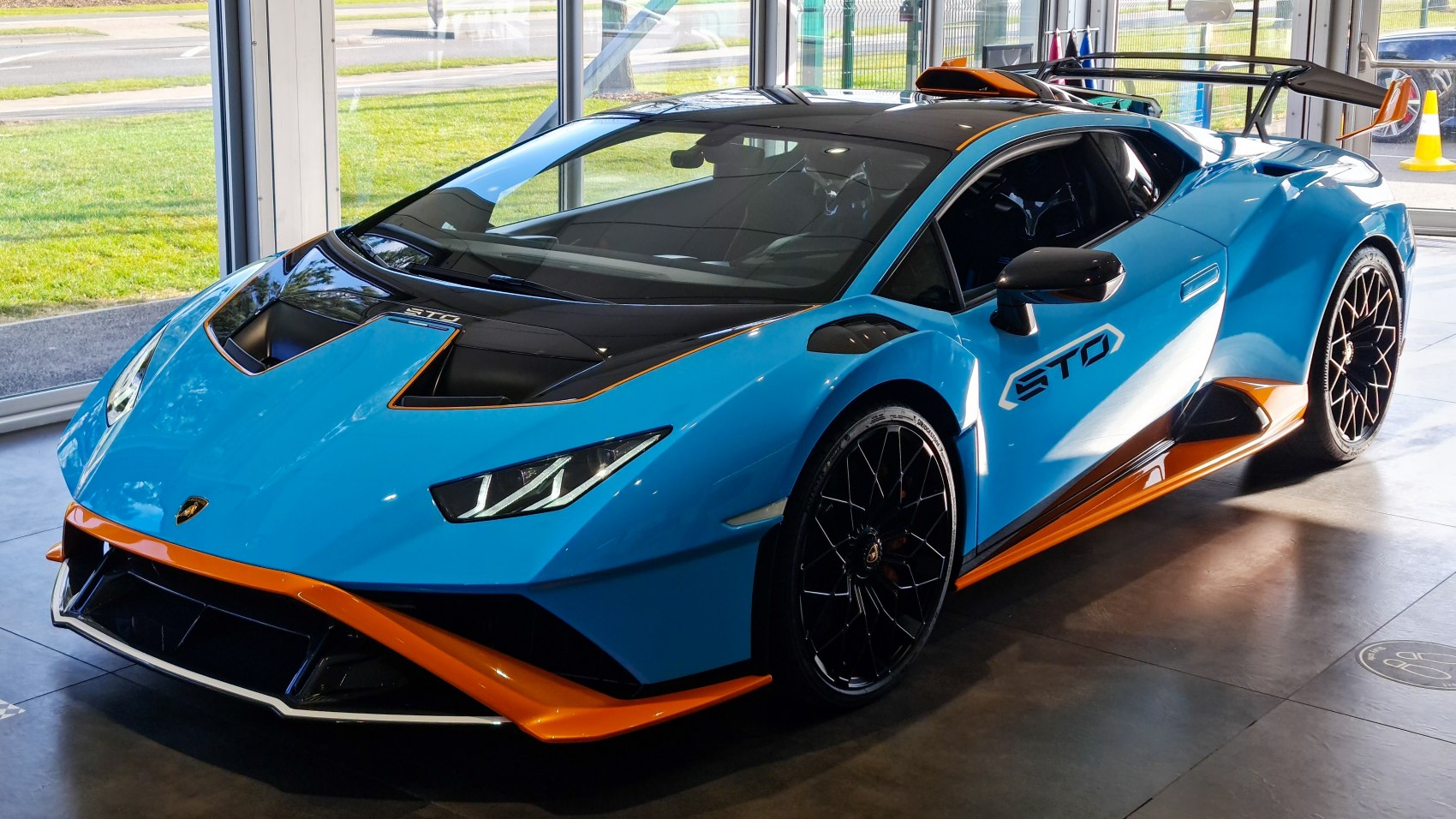 Vibrant blue and orange Lamborghini with aerodynamic body and rear wing spoiler
