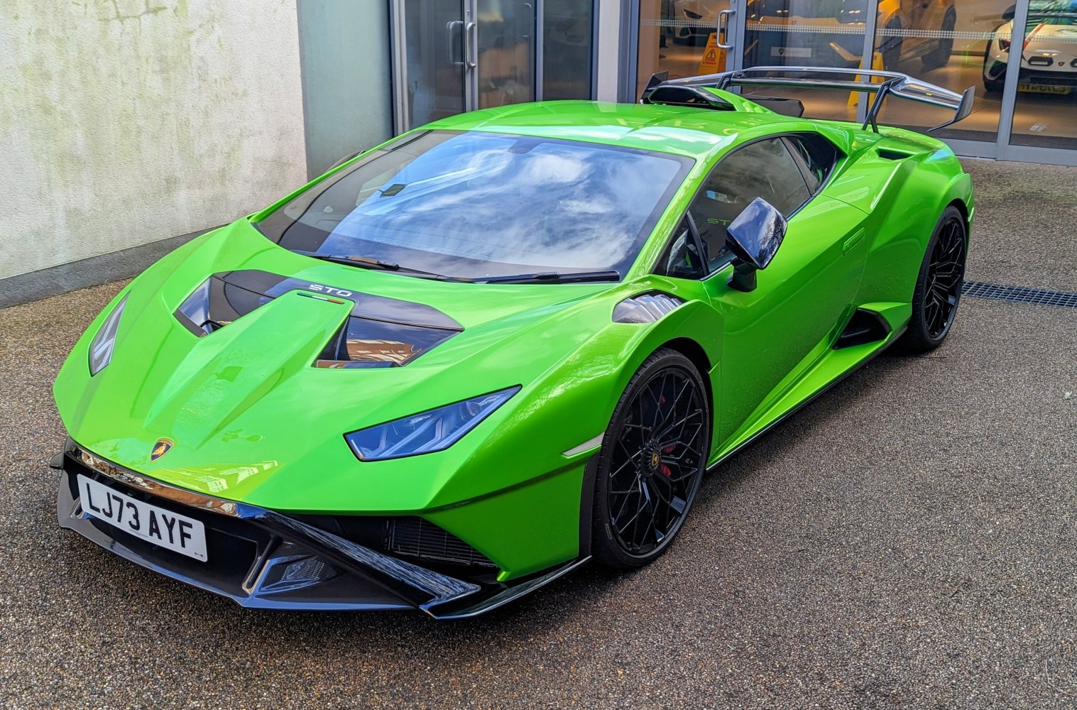 Aerodynamic design with rear wing and sharp front.