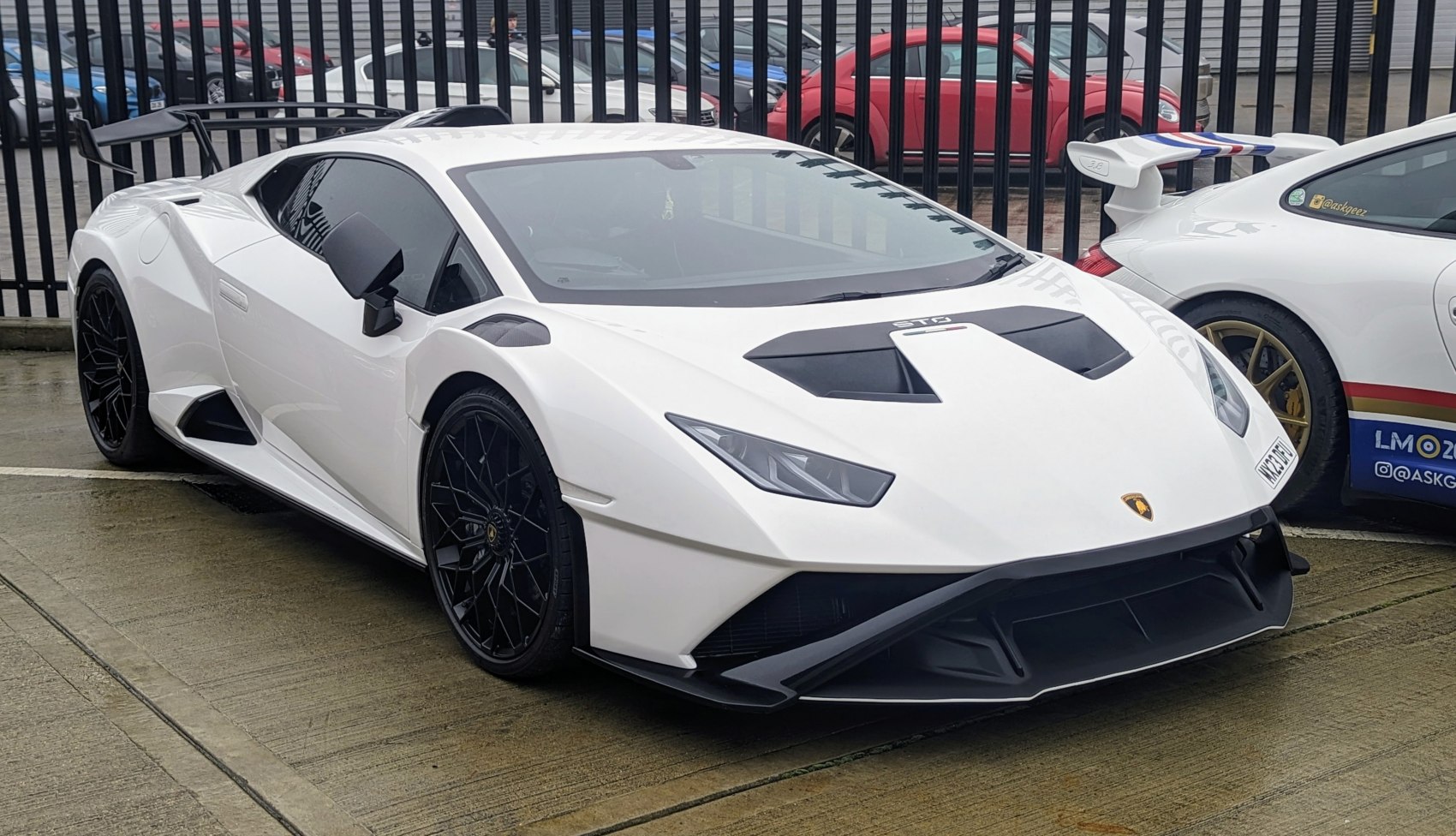 White high-performance sports car with aggressive aero, black multi-spoke wheels