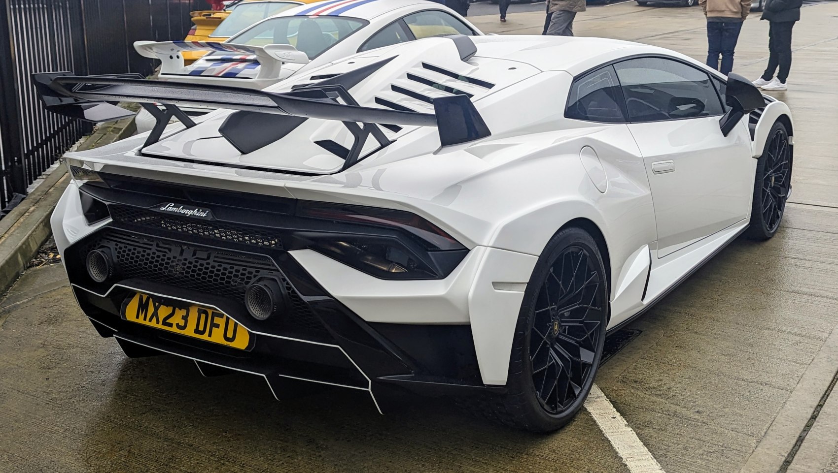 White sports car rear with large aerodynamic wing and aggressive diffuser