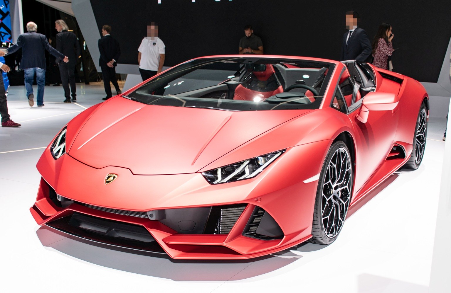 Matte red convertible with sharp LED headlights and aerodynamic front design