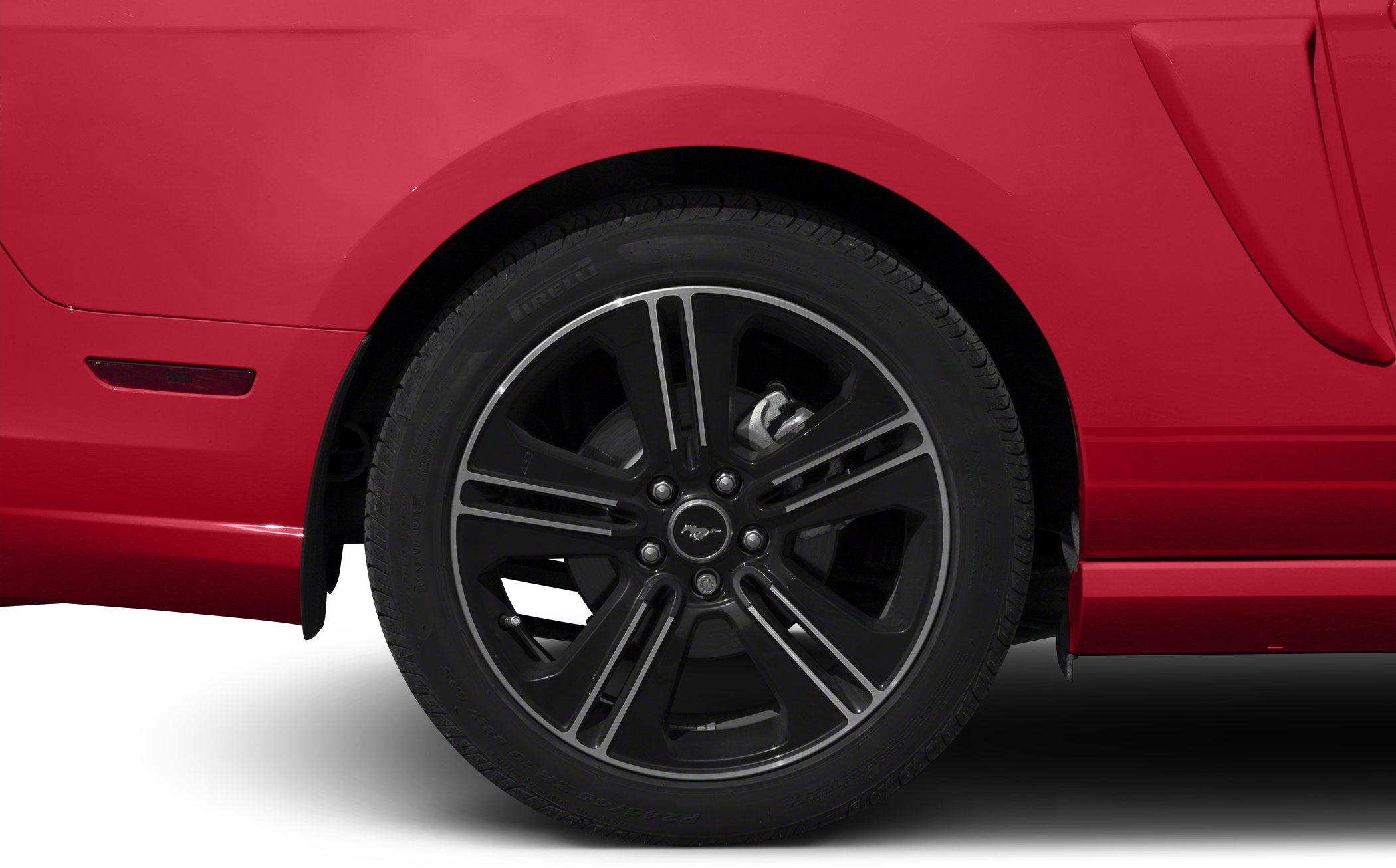 Close-up of black alloy wheel and tire on red vehicle side.