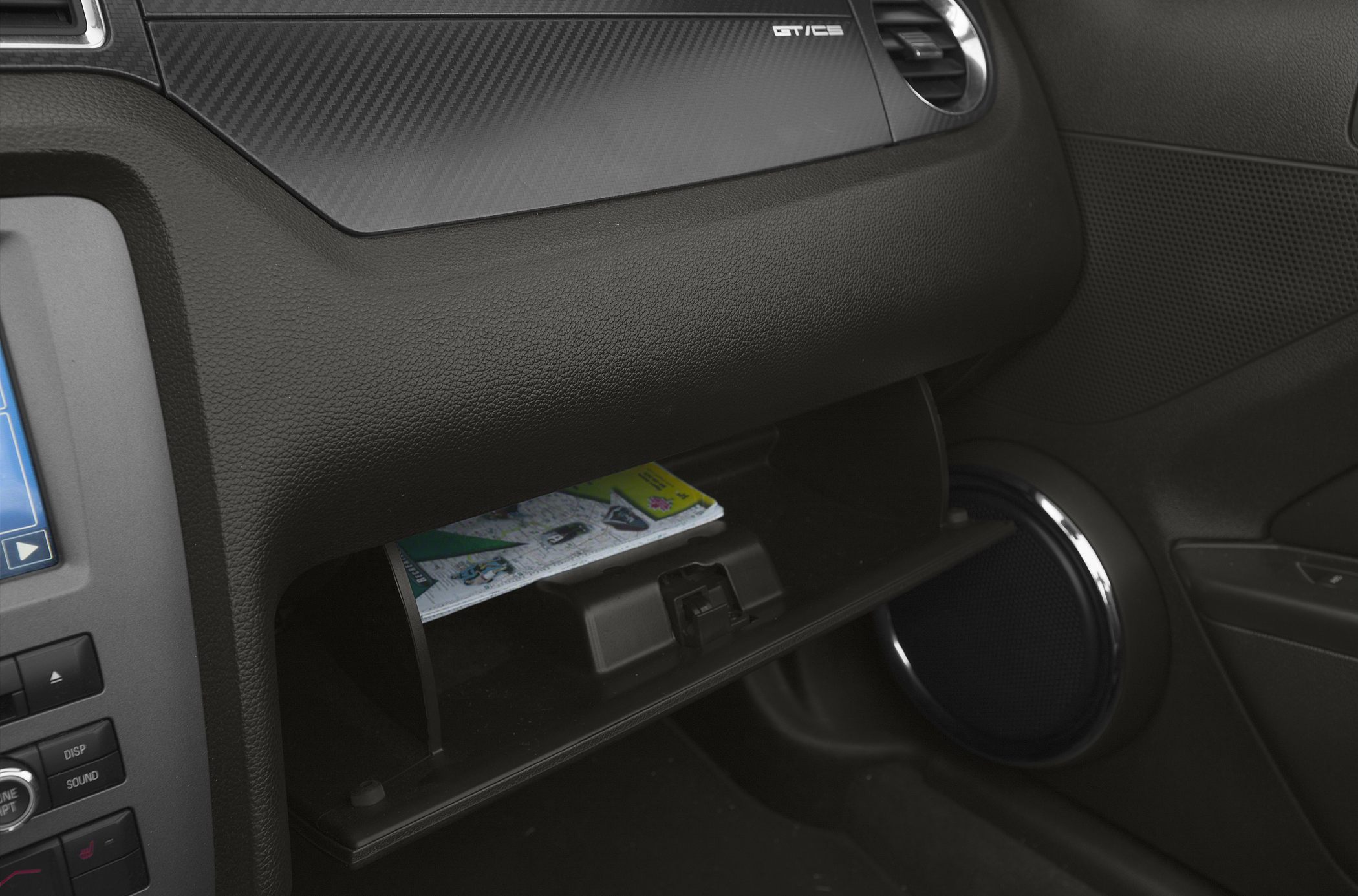 Opened glovebox and carbon fiber dashboard trim with GT/CS badge