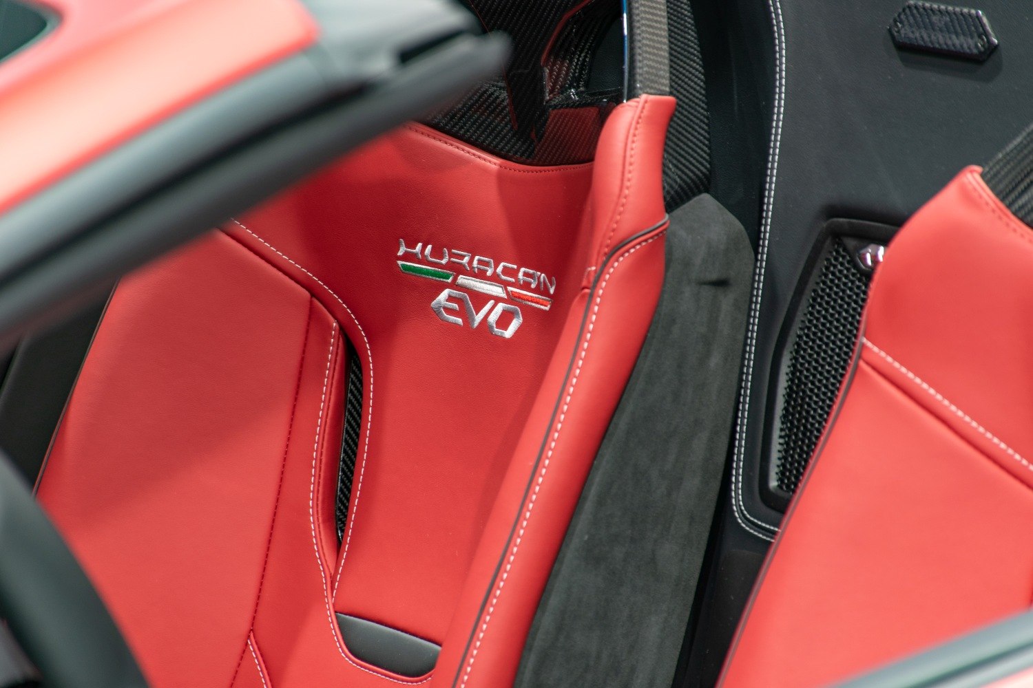 Red leather racing-style seat with Huracan EVO embroidery and Italian flag colors.