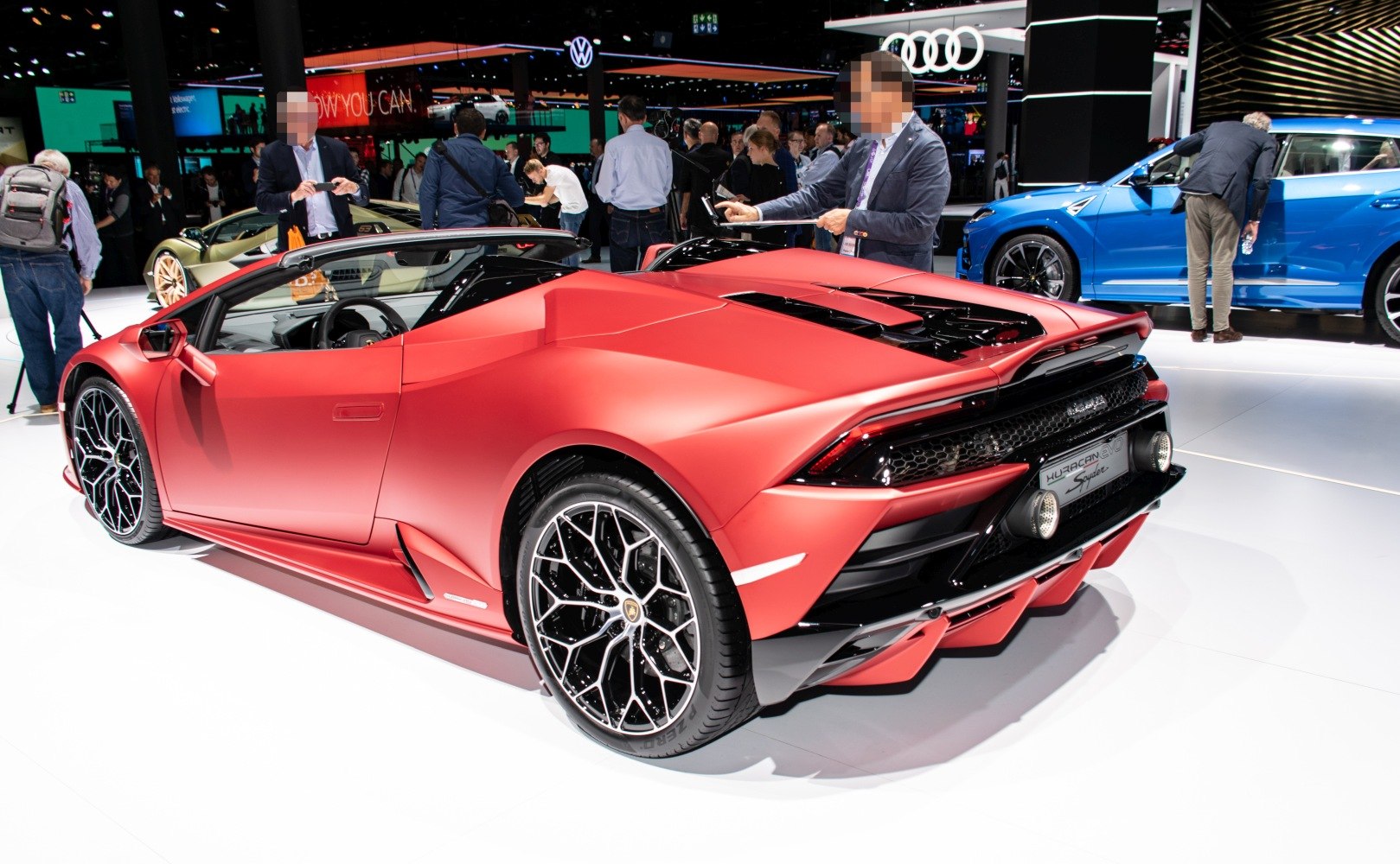 Matte red convertible with rear diffuser, unique wheels and open roof.