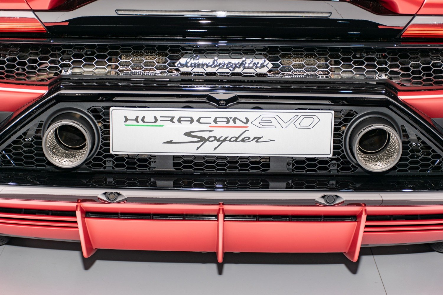 Close-up of rear dual exhausts and badges with hexagonal grille