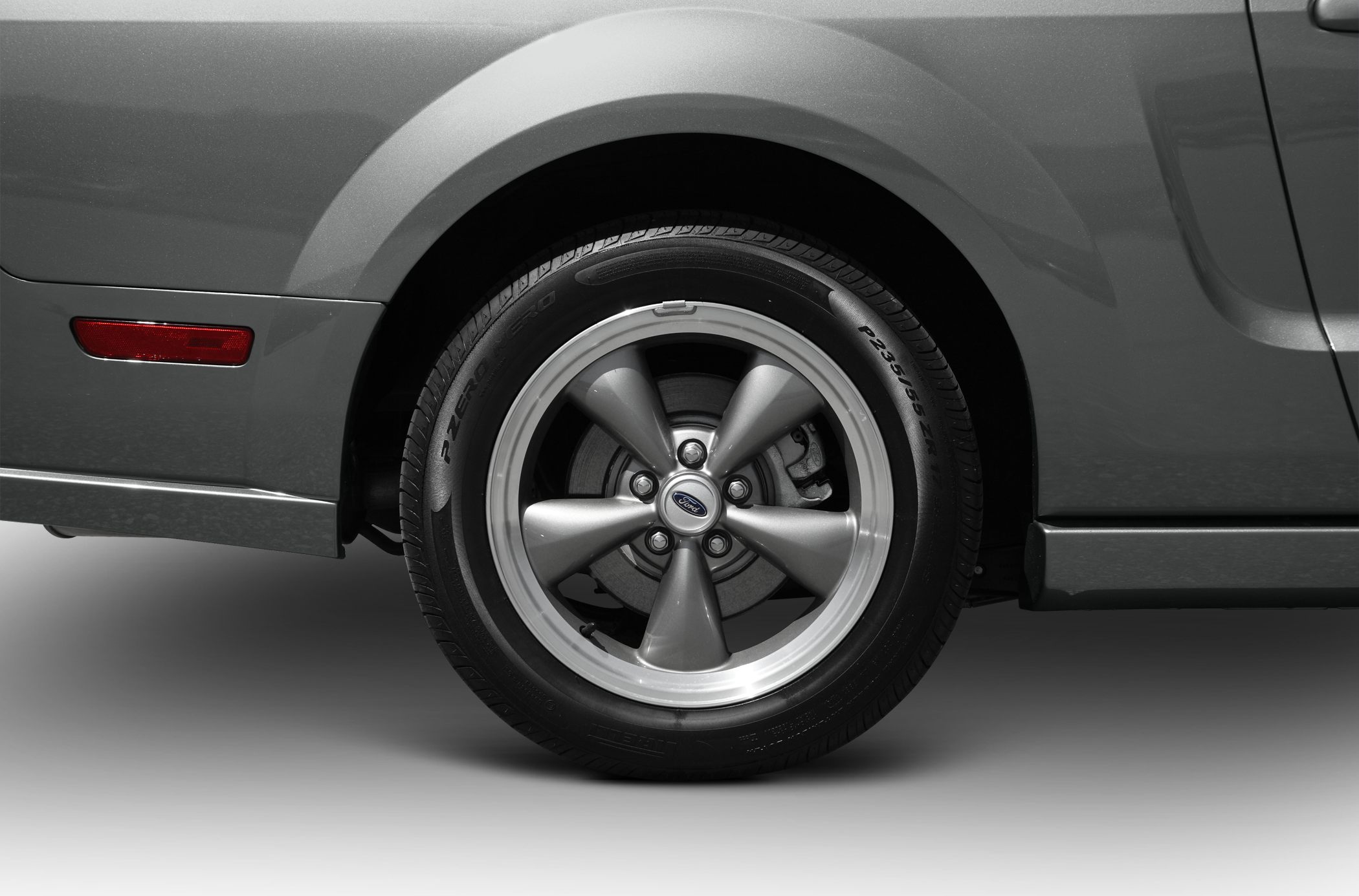 Close-up of five-spoke alloy wheel and tire on vehicle rear side