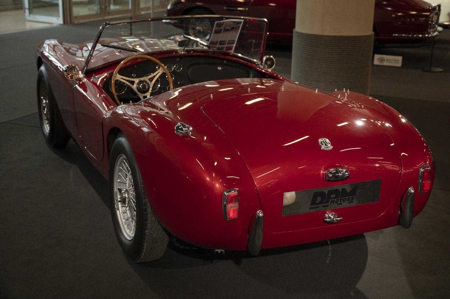 Red vintage convertible with wooden steering wheel and wire wheels