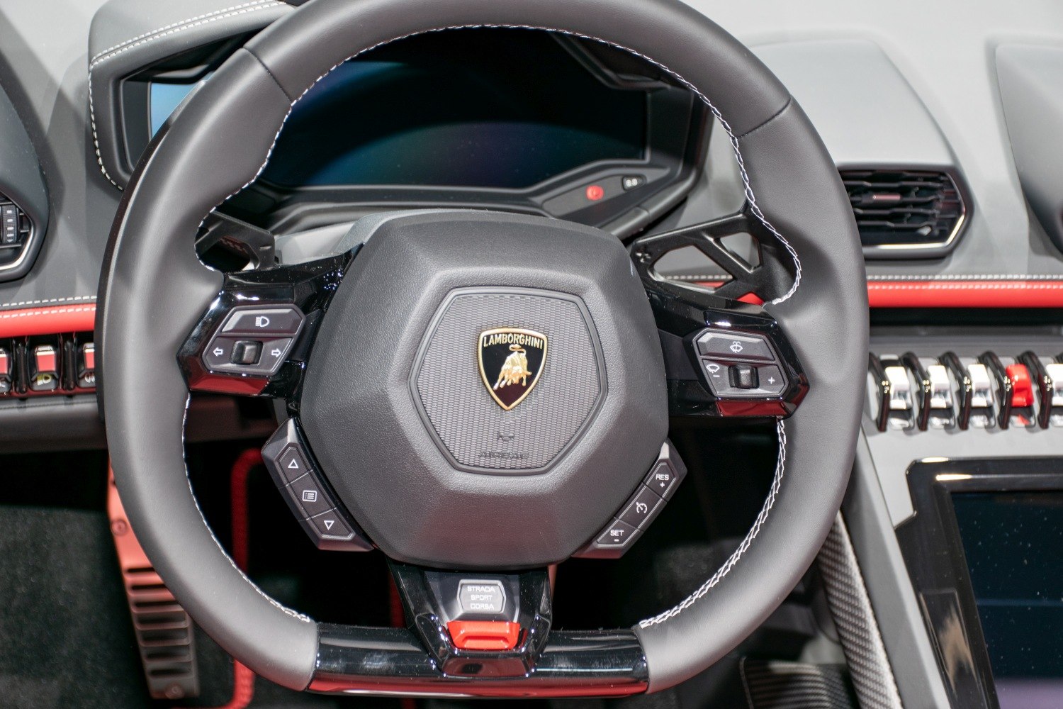Close-up of luxury steering wheel with control buttons and emblem