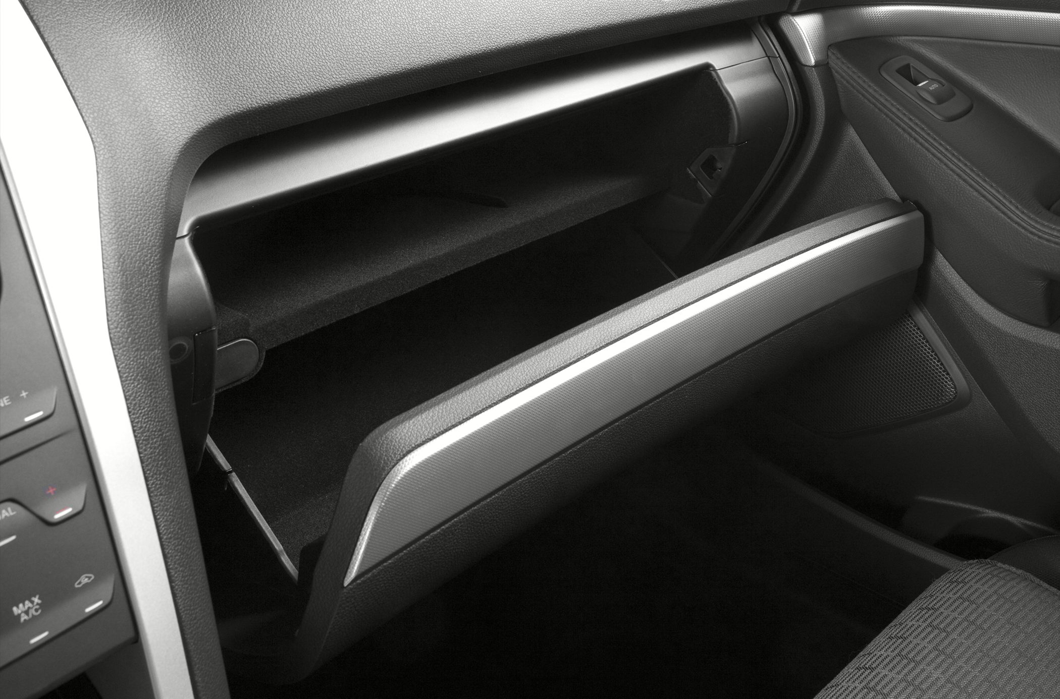 Open glove box and passenger door panel interior with textured surfaces.
