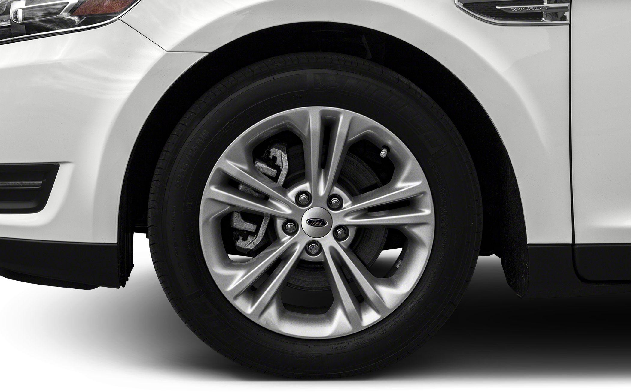 Alloy wheel with visible brake disc and caliper on white vehicle.