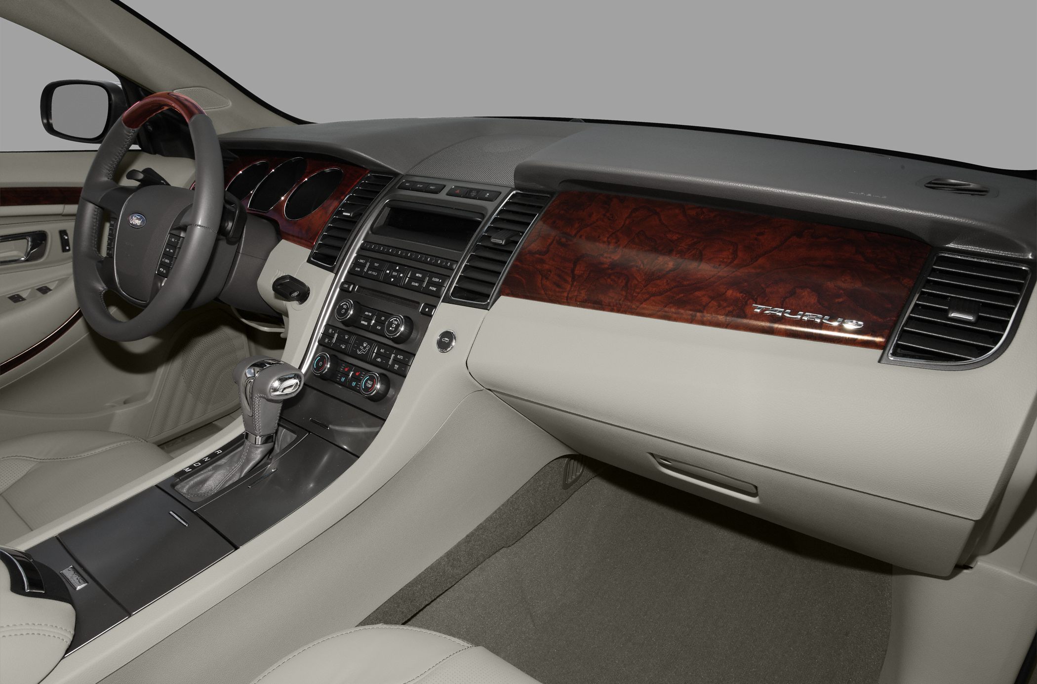 Luxurious car interior with wood trim, gear shift, and multi-function steering wheel