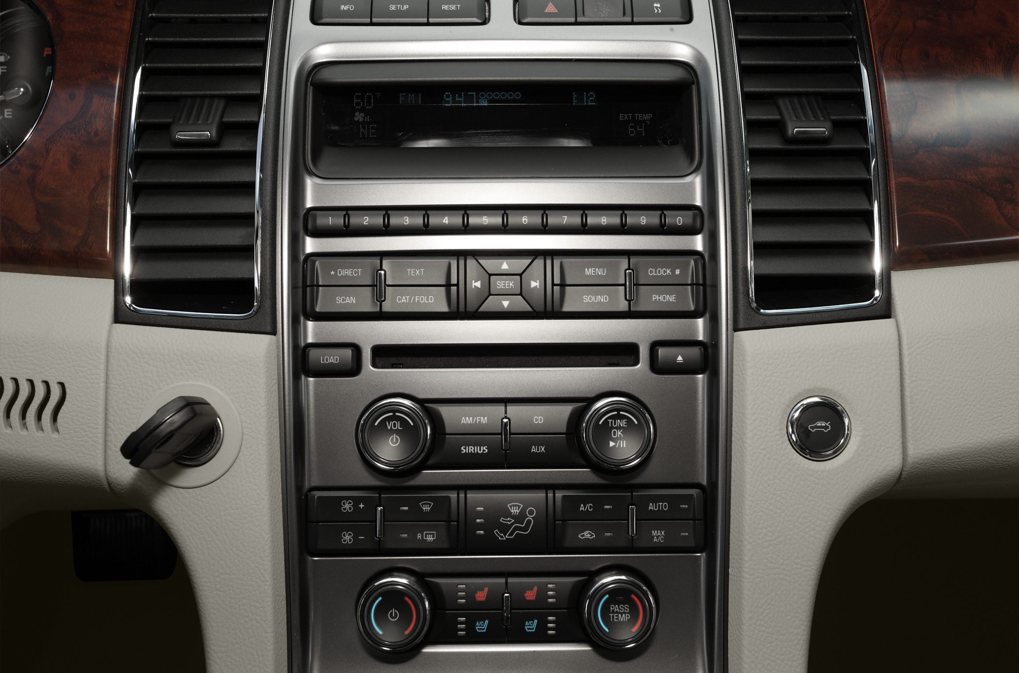 Center console with audio and climate control knobs, buttons, and air vents