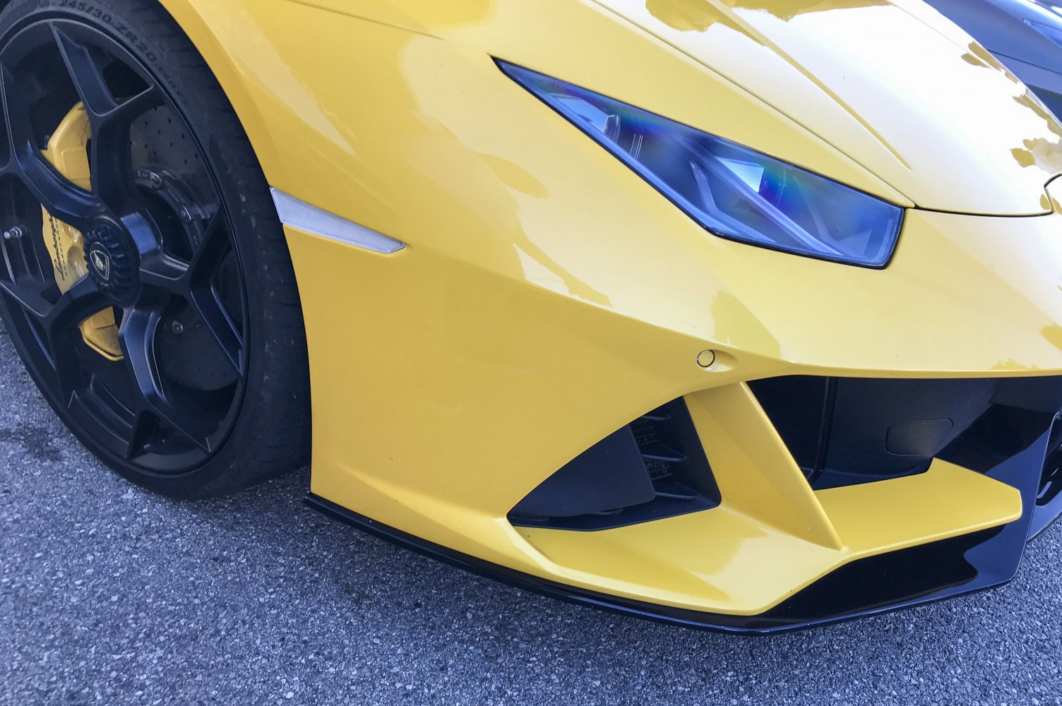 Sharp headlight and black alloy wheel with yellow brake caliper