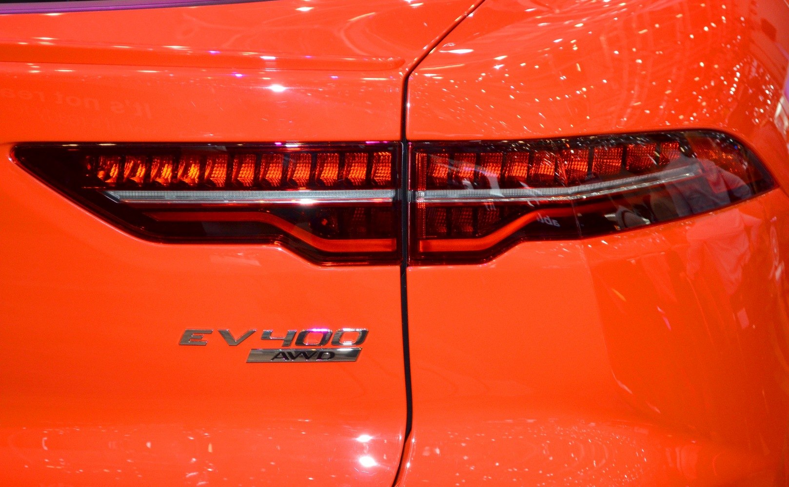 Jaguar I-Pace rear LED taillights with EV400 AWD badge on orange paint