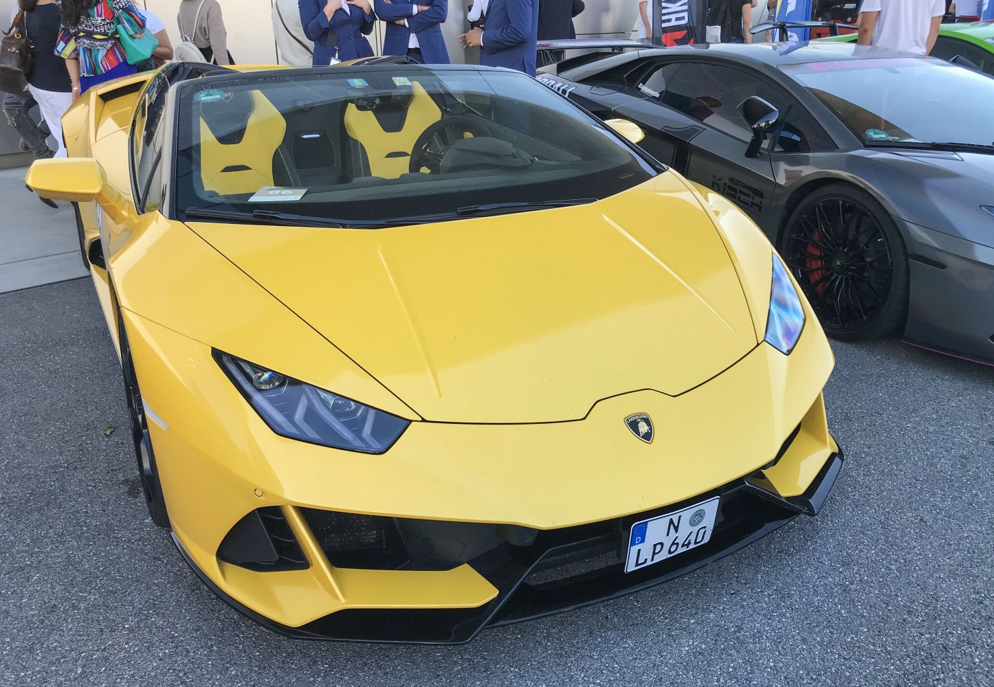 Yellow convertible sports car front with sharp LED headlights and aggressive aerodynamic design