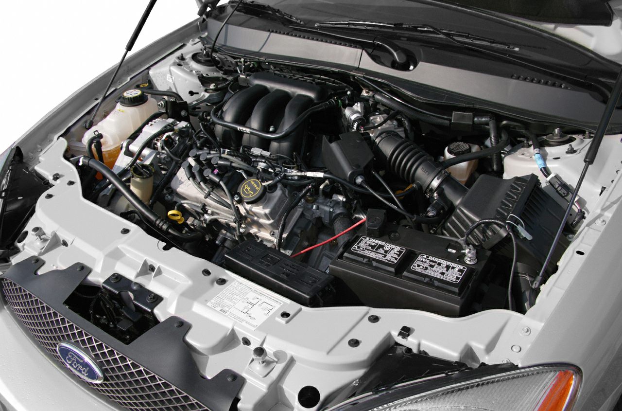 Detailed engine bay with visible intake manifold, battery, and fluid reservoirs