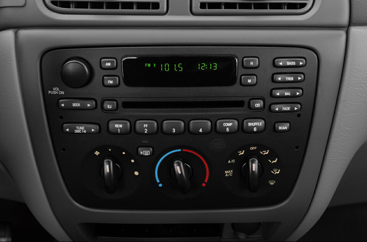Car stereo display and manual climate control knobs on dashboard
