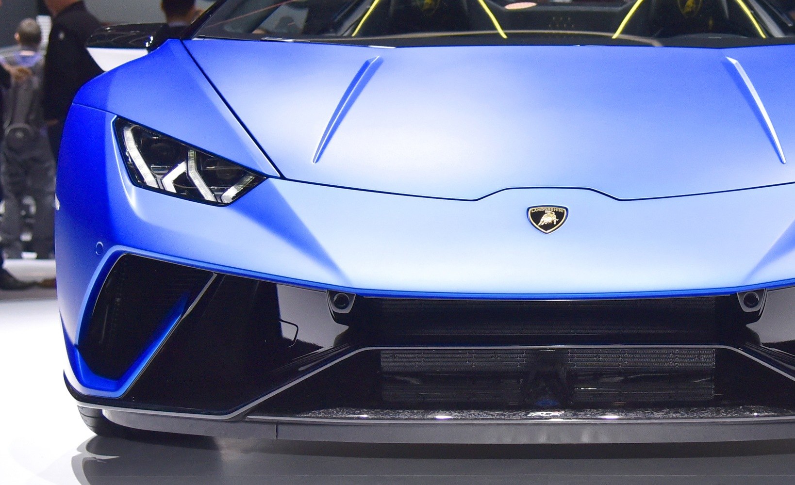 Front end and sharp LED headlights of a matte blue sports car