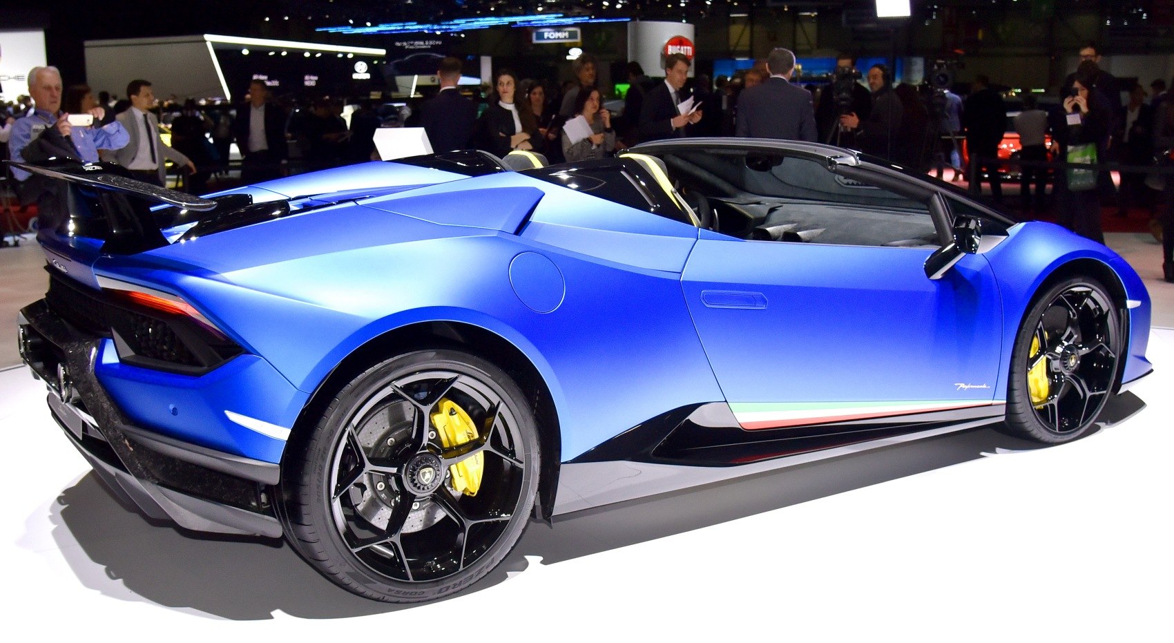 Rear and side profile of blue matte convertible with black wheels and yellow brake calipers.