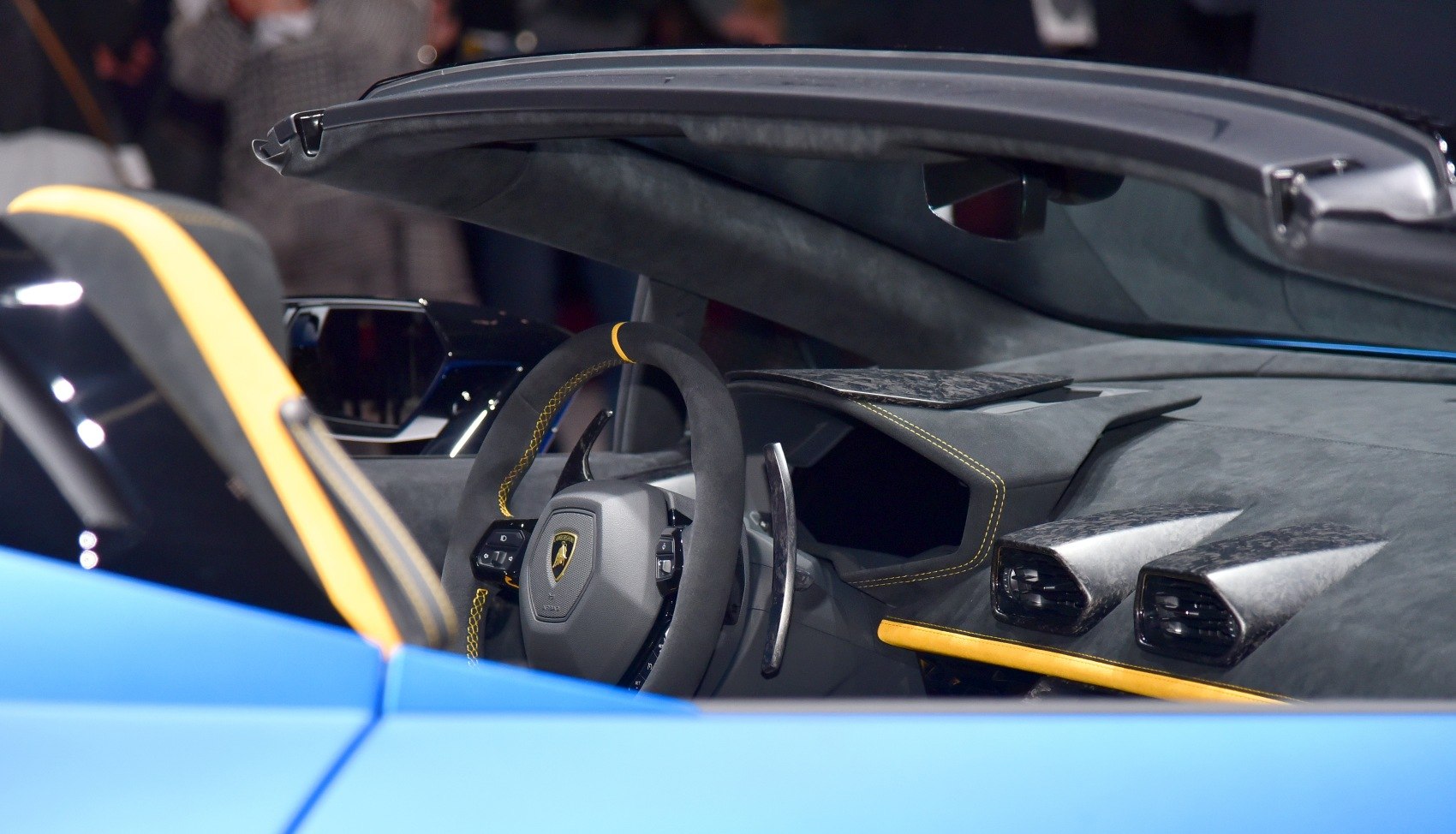 Close-up of sports car steering wheel and dashboard with carbon fiber vents