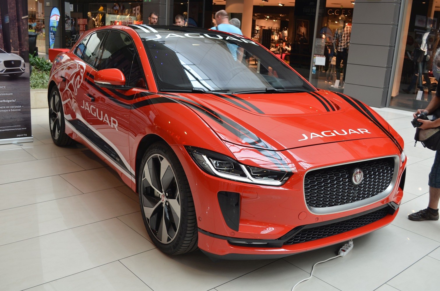 Front view of electric SUV with LED headlights and black racing stripes