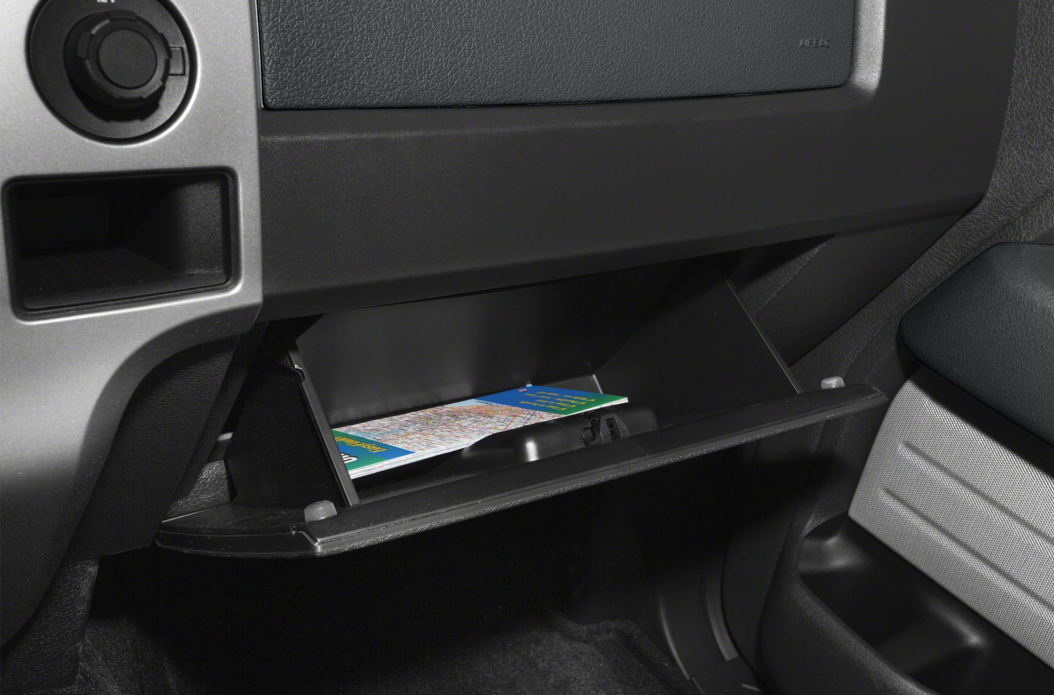 Open glove compartment with a map inside in vehicle interior