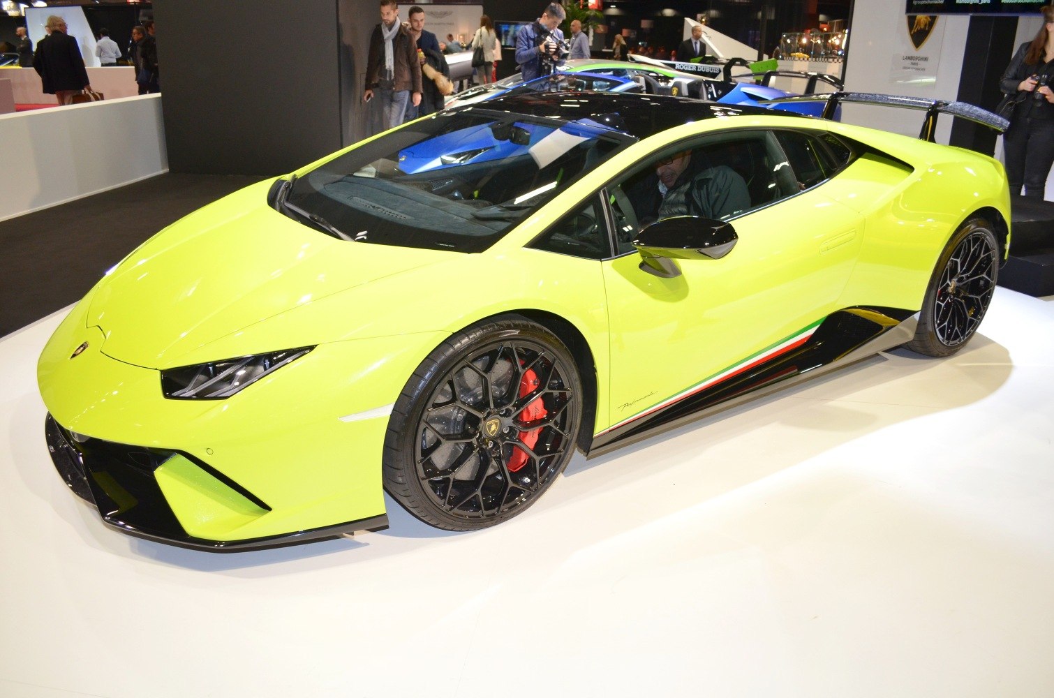 Yellow sports coupe with black roof, large rear wing, and black multi-spoke wheels