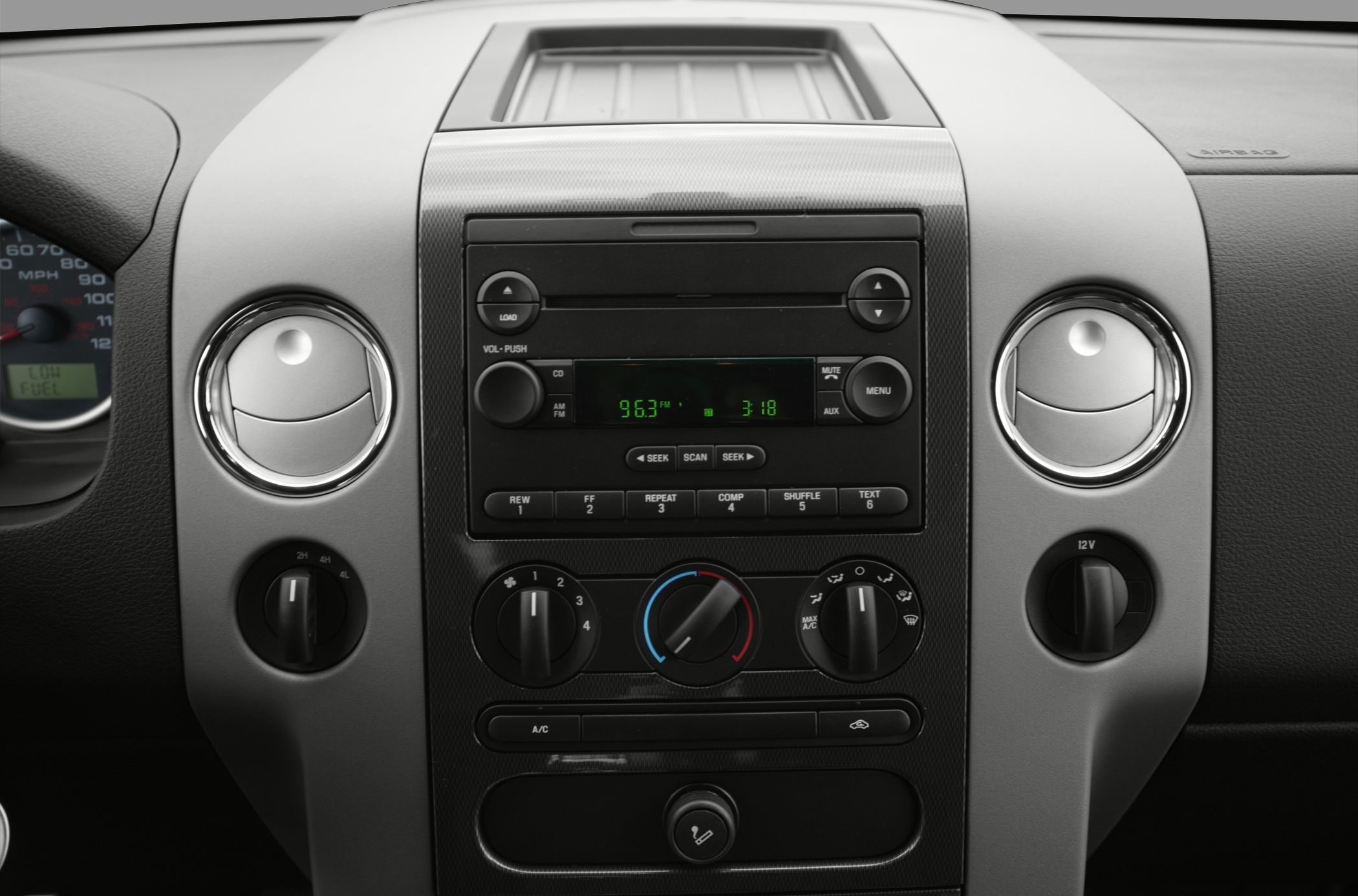 Dashboard with radio, air conditioning dials, and circular air vents.