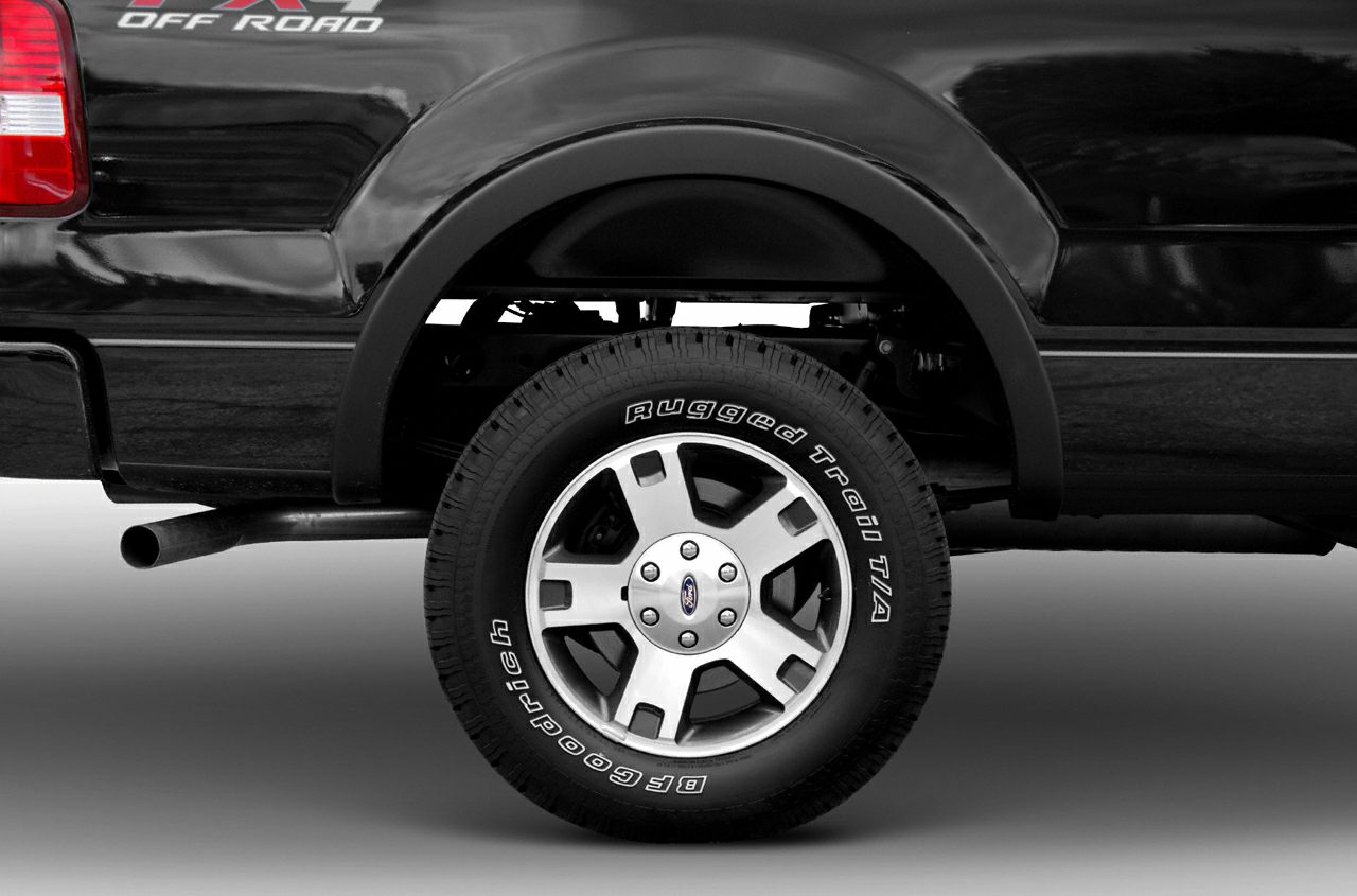 Rear wheel with off-road badge and rugged tire on black pickup