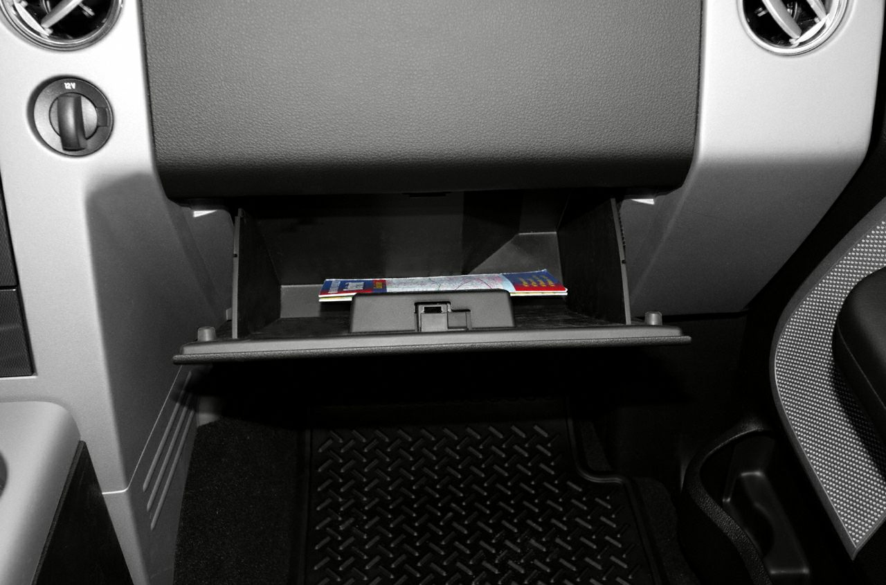 Open glove compartment with a map inside in vehicle interior