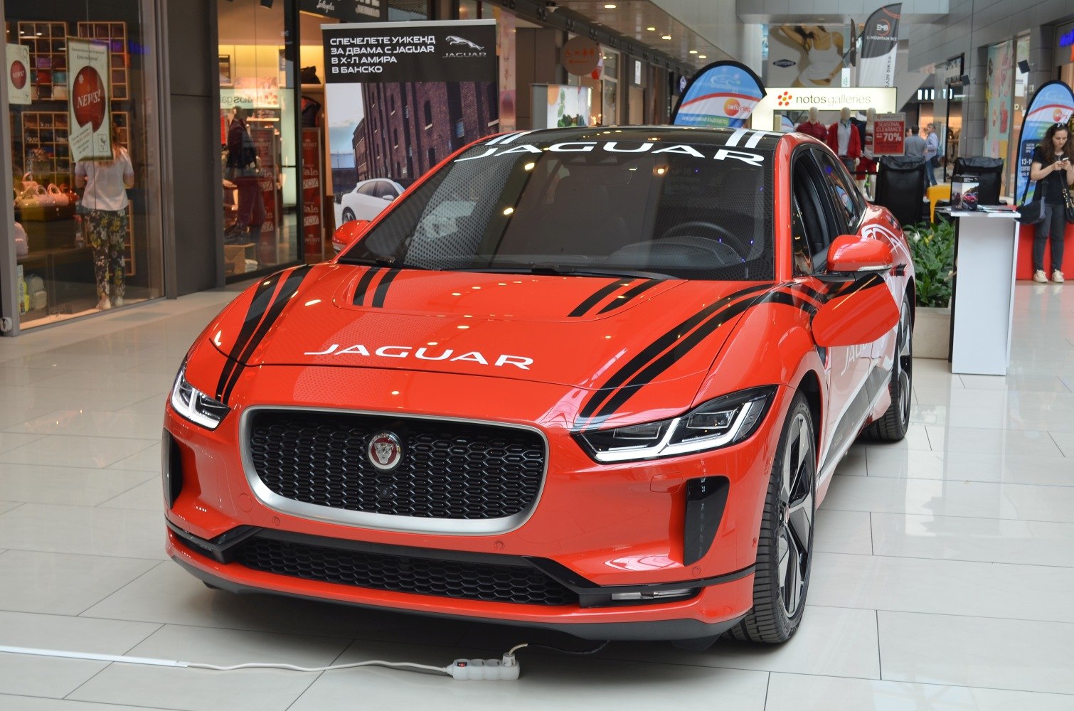 Front view of an EV with black race stripes and LED headlights