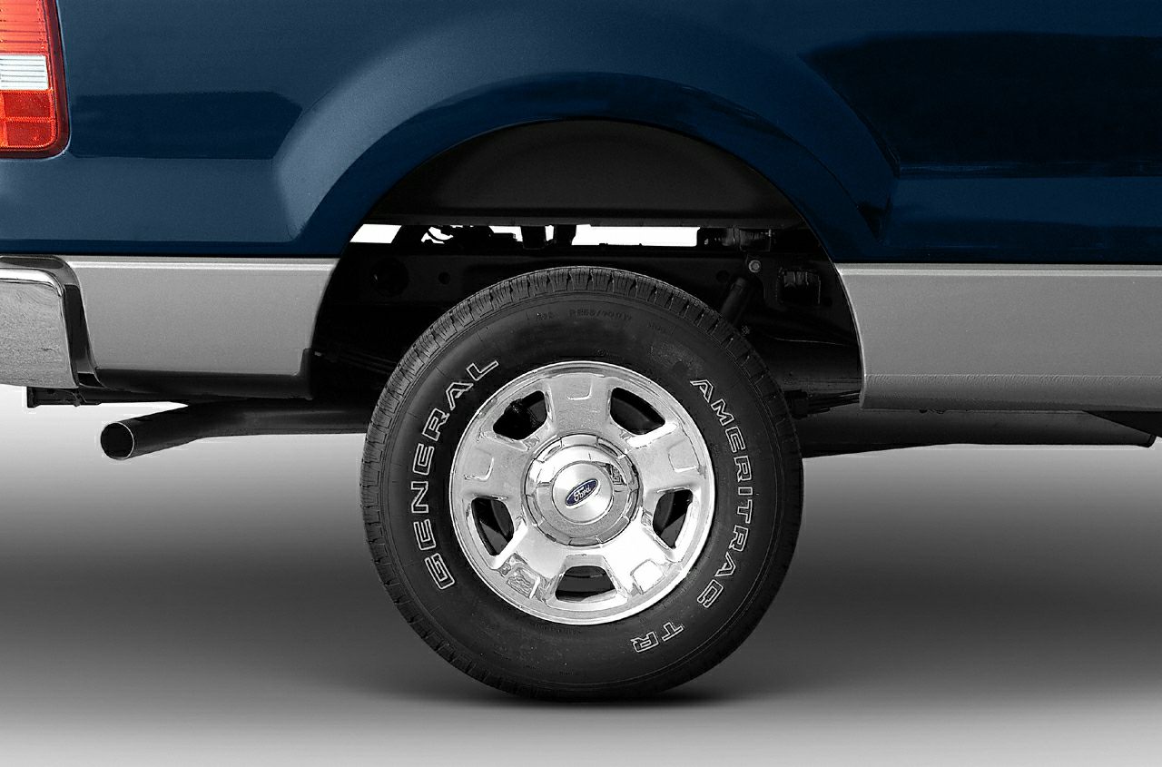 Close-up of rear wheel, tire, and exhaust pipe of a pickup truck
