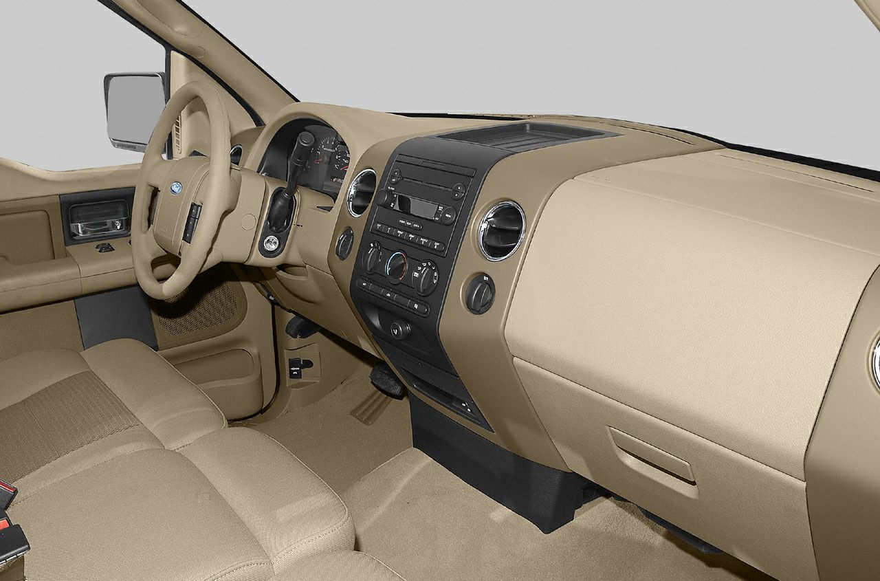 Beige truck interior with dashboard, steering wheel, and center console.
