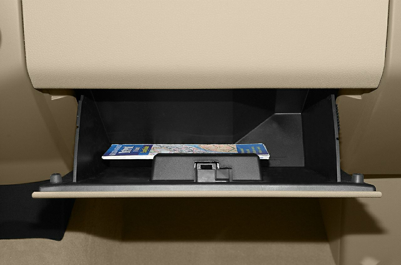 Open glove box storage compartment with map inside