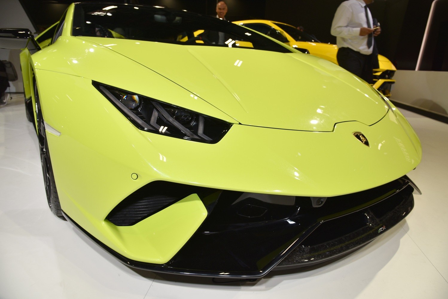 Aggressive headlights and aerodynamic front end of yellow sports car
